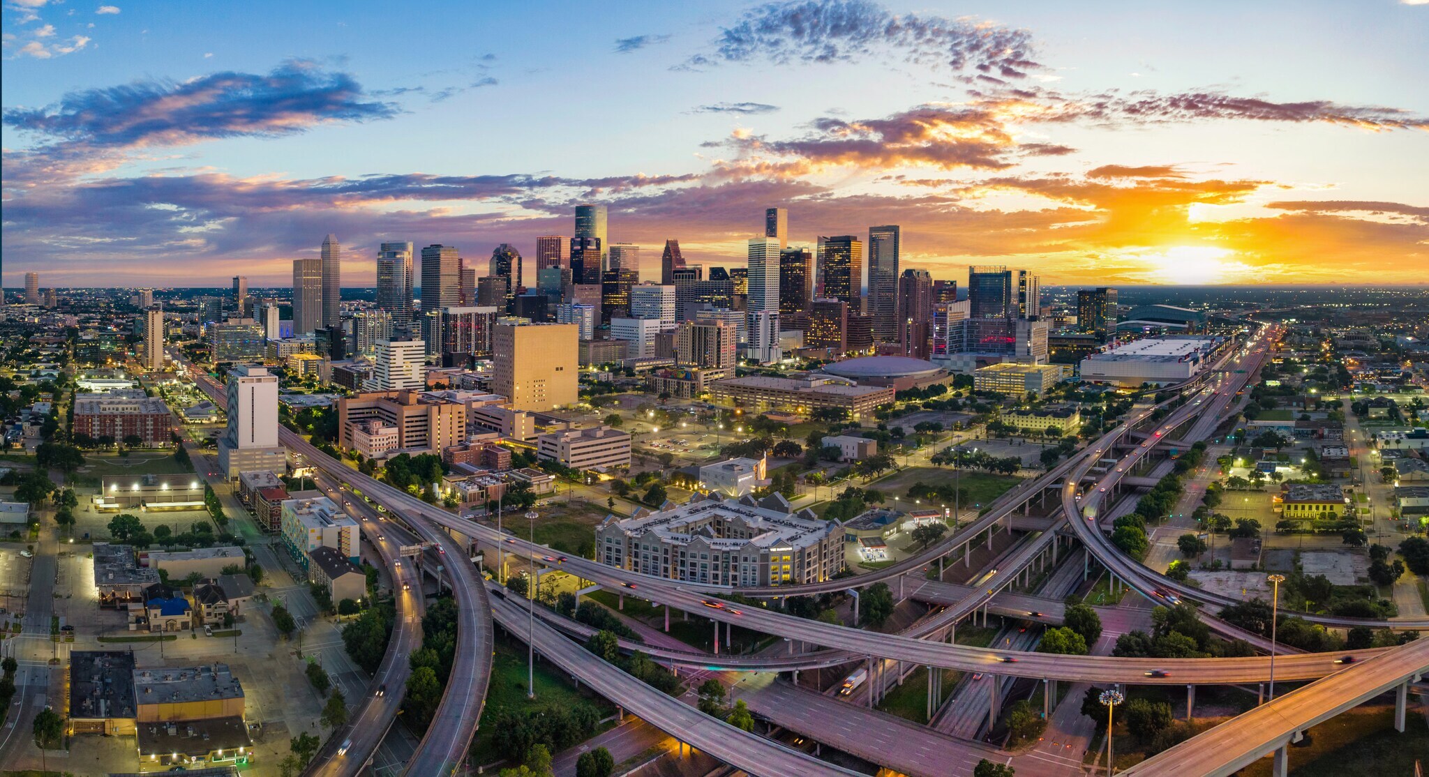 Skyline von Houston mit Autobahnkreuz bei Sonnenuntergang.