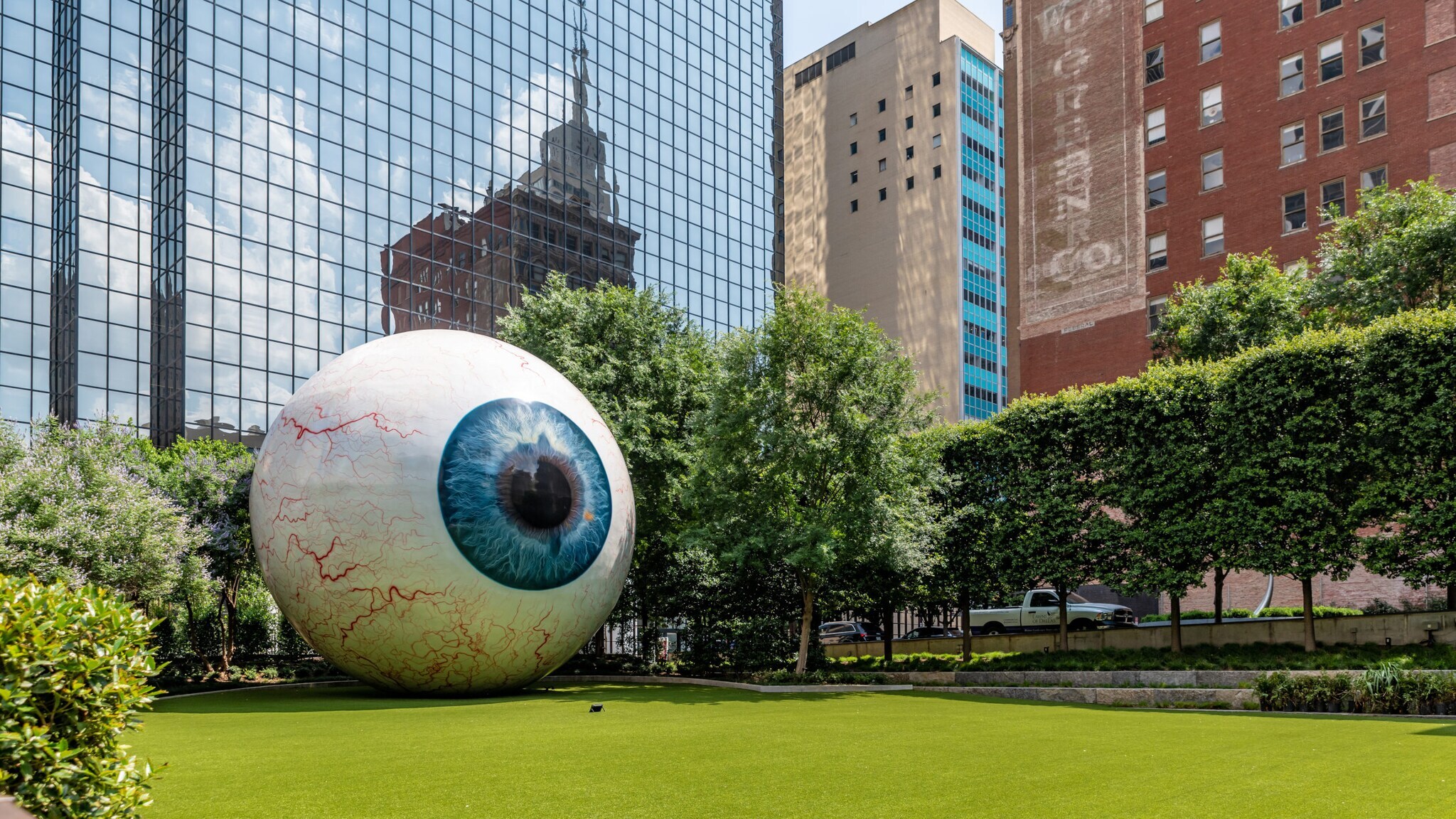 Ein große, runde Kunstinstallation in Form eines Augapfels auf einer Grünfläche im Stadtzentrum. Ein große, runde Kunstinstallation in Form eines Augapfels auf einer Grünfläche im Stadtzentrum.