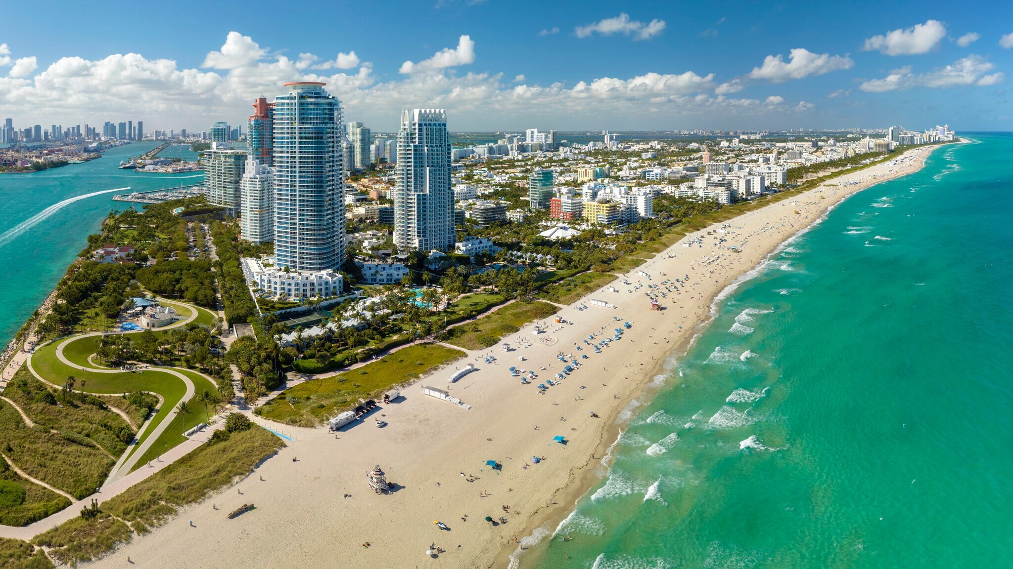 Skyline von Miami Beach mit breitem Sandstrand am türkisblauen Meer bei Sonnenschein.