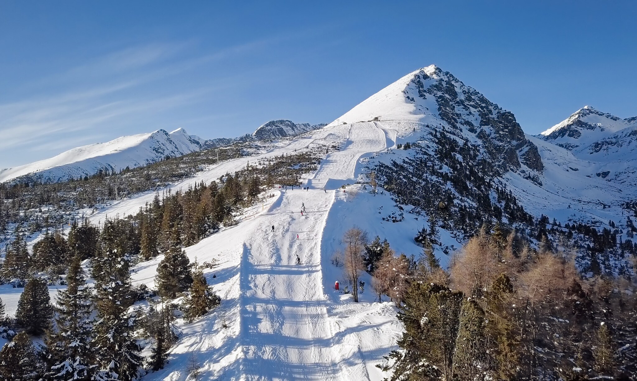 Personen auf einer Skipiste auf einem Berg.