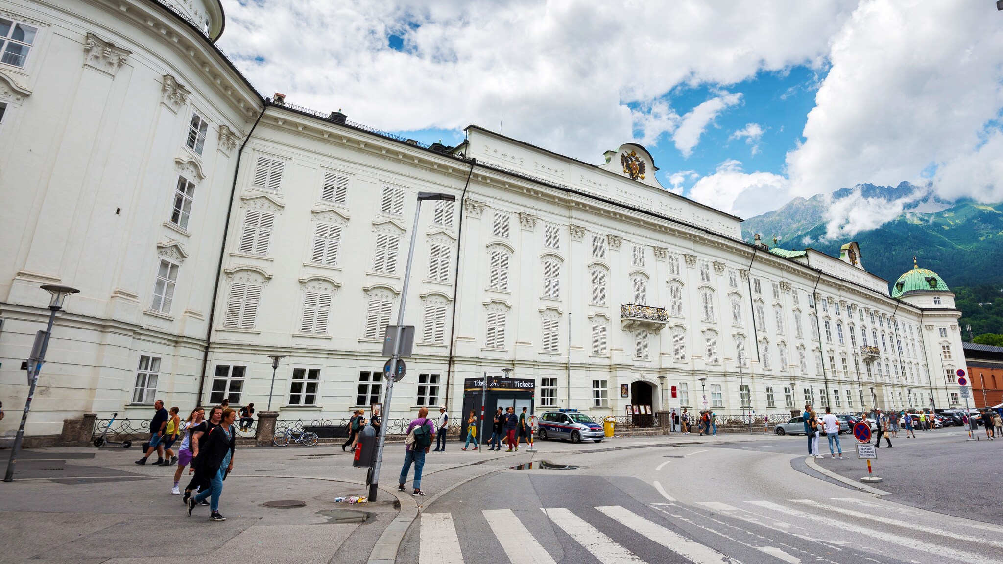 Imposantes weißes Gebäude im spätgotischen Stil in einer Stadt vor Bergpanorama. Imposantes weißes Gebäude im spätgotischen Stil in einer Stadt vor Bergpanorama.