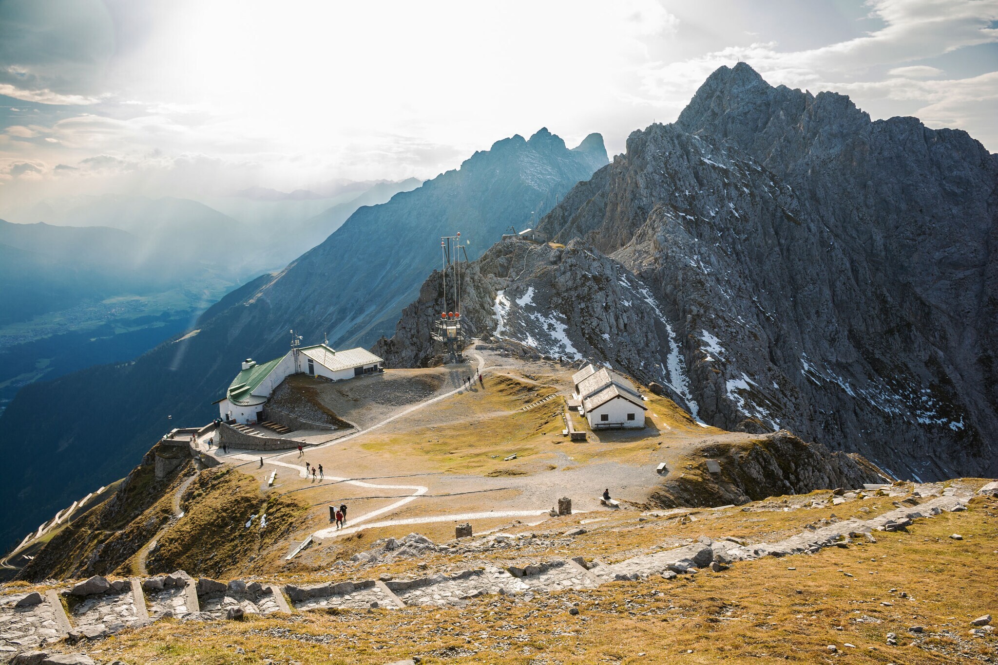 Bergstation vor Gipfelpanorama bei Sonnenschein.