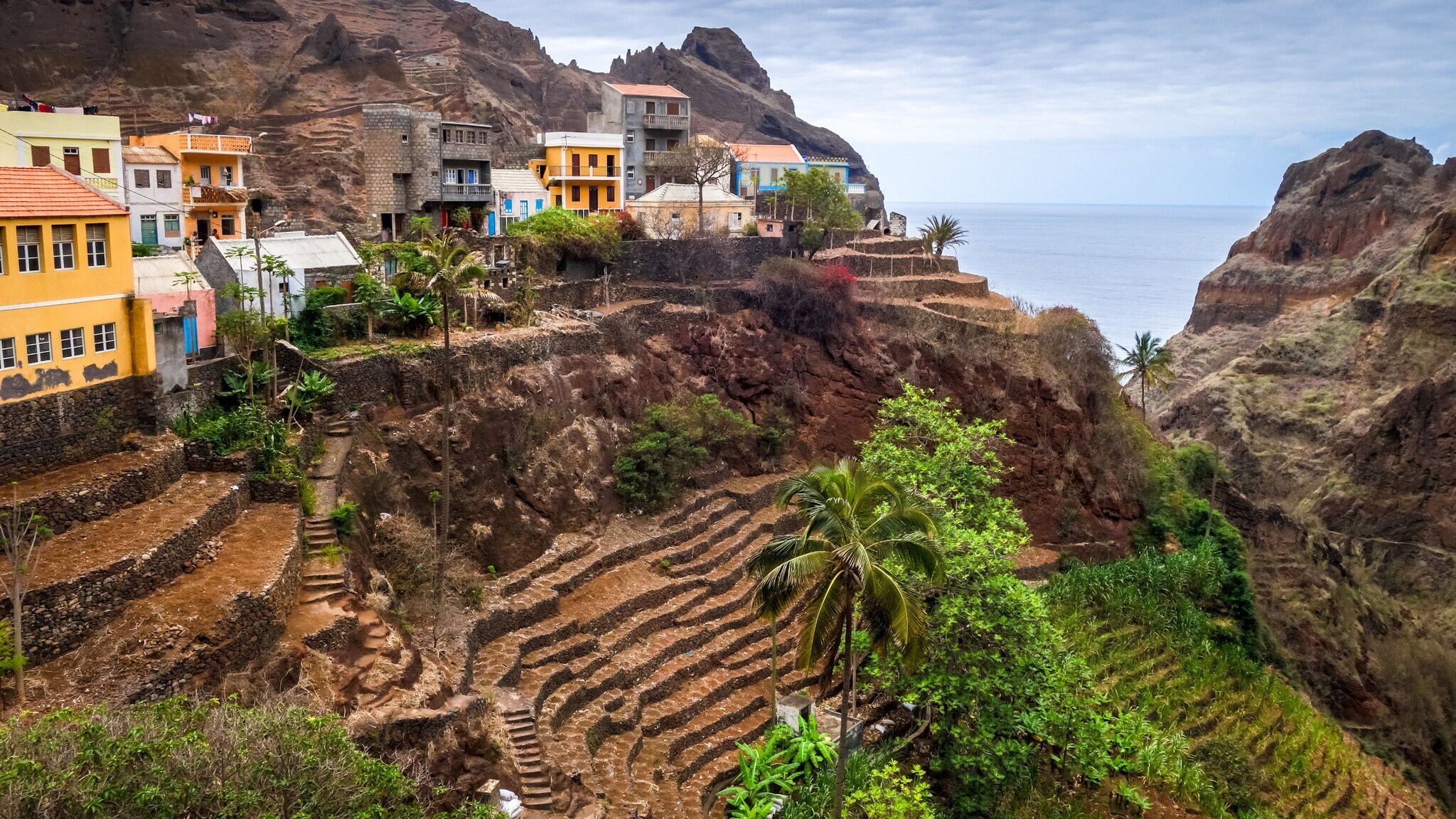 Bunte Häuser an einem steilen, terrassenförmigen Abhang.