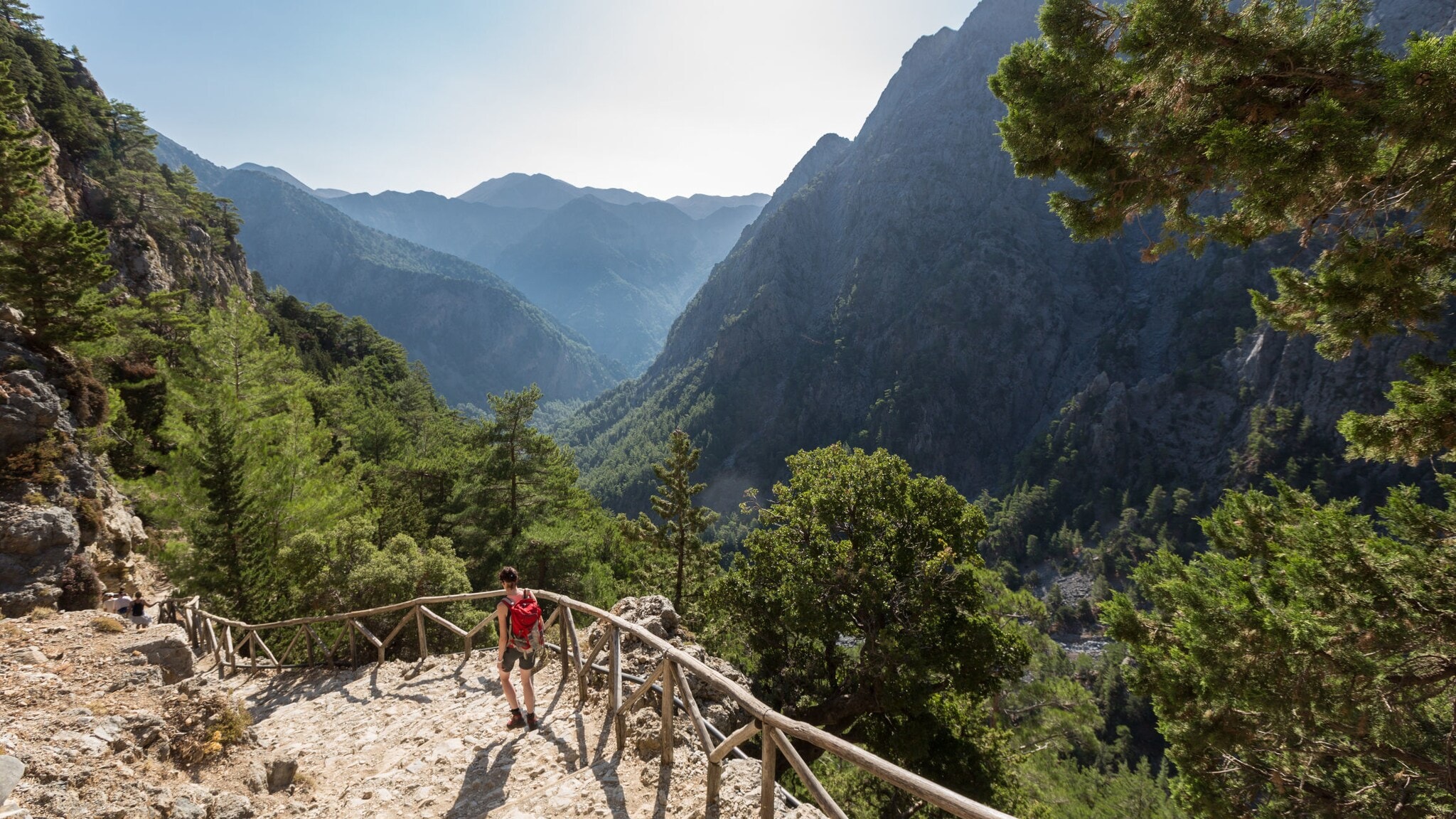 Eine Person beim Wandern in der Samaria-Schlucht auf Kreta, im Hintergrund Vegetation und Berggipfel. Eine Person beim Wandern in der Samaria-Schlucht auf Kreta, im Hintergrund Vegetation und Berggipfel.