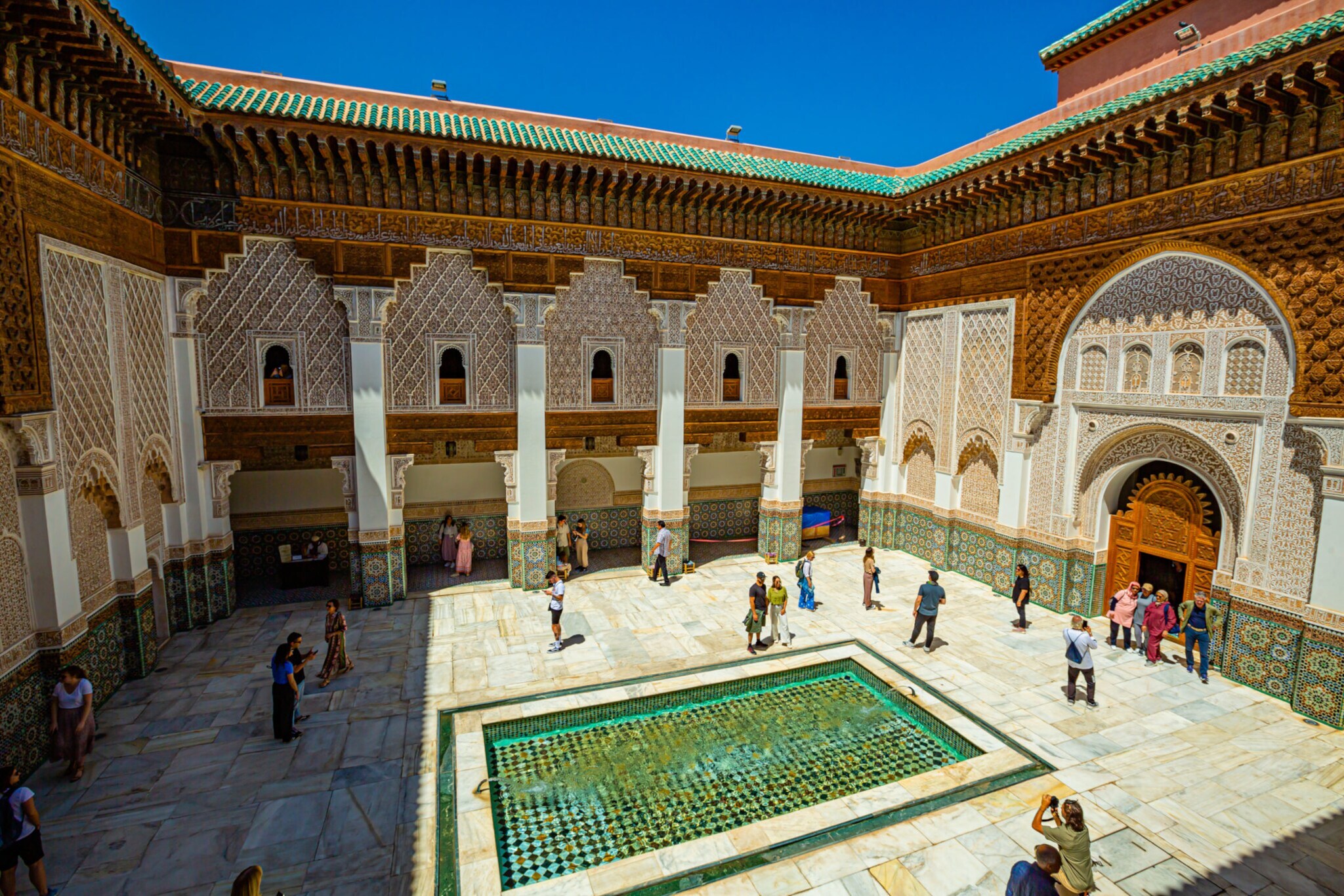 Personen in einem Innenhof im maurischen Stil mit Brunnen. Personen in einem Innenhof im maurischen Stil mit Brunnen.