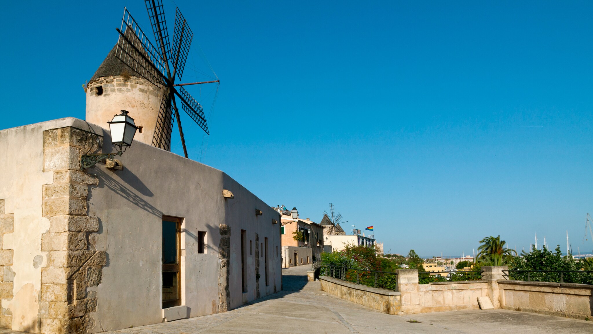 Flache, weiße Gebäude mit Windmühle an einem Weg auf einer Anhöhe. Flache, weiße Gebäude mit Windmühle an einem Weg auf einer Anhöhe.