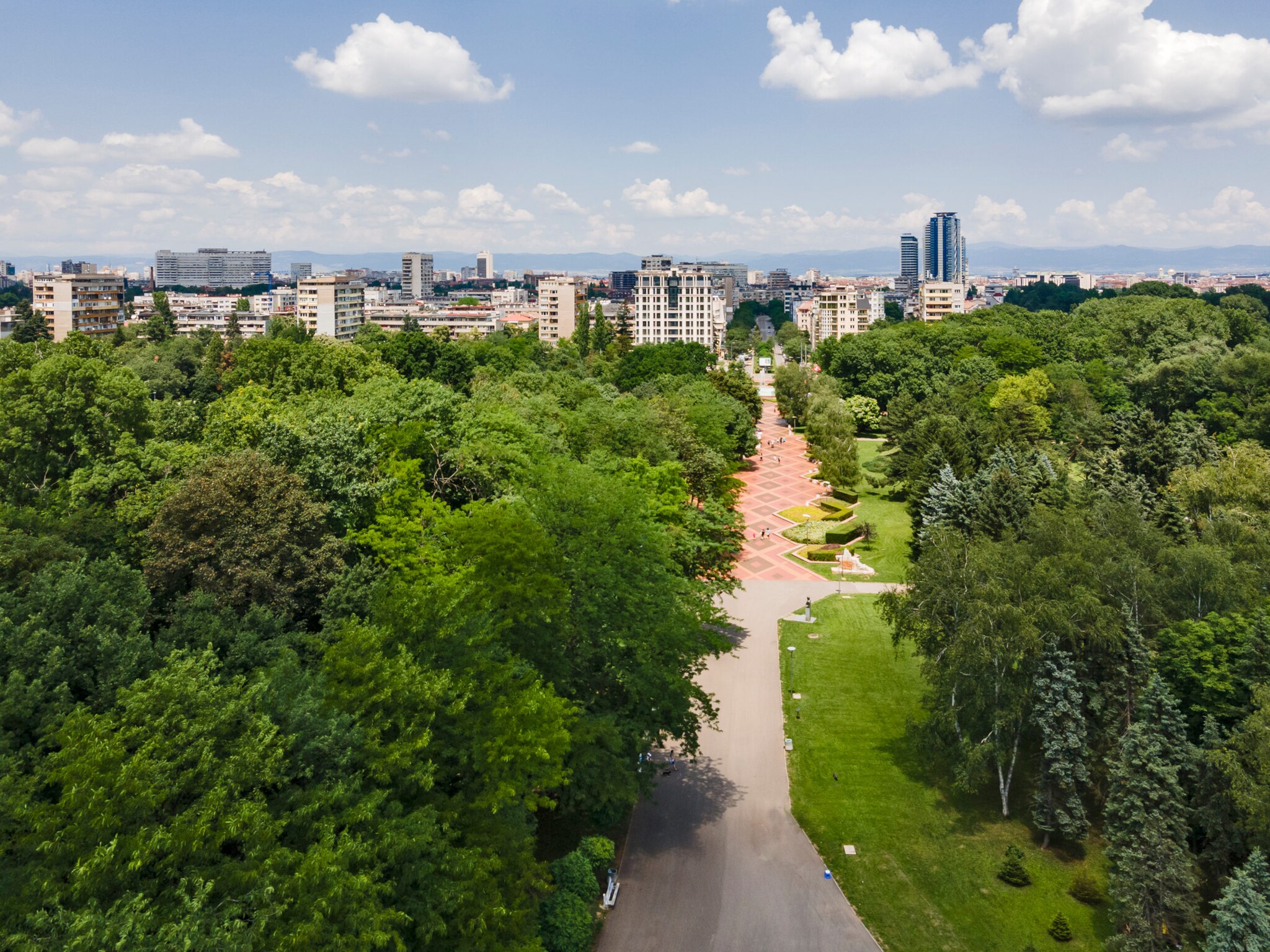 Große Parklandschaft vor einer Skyline.