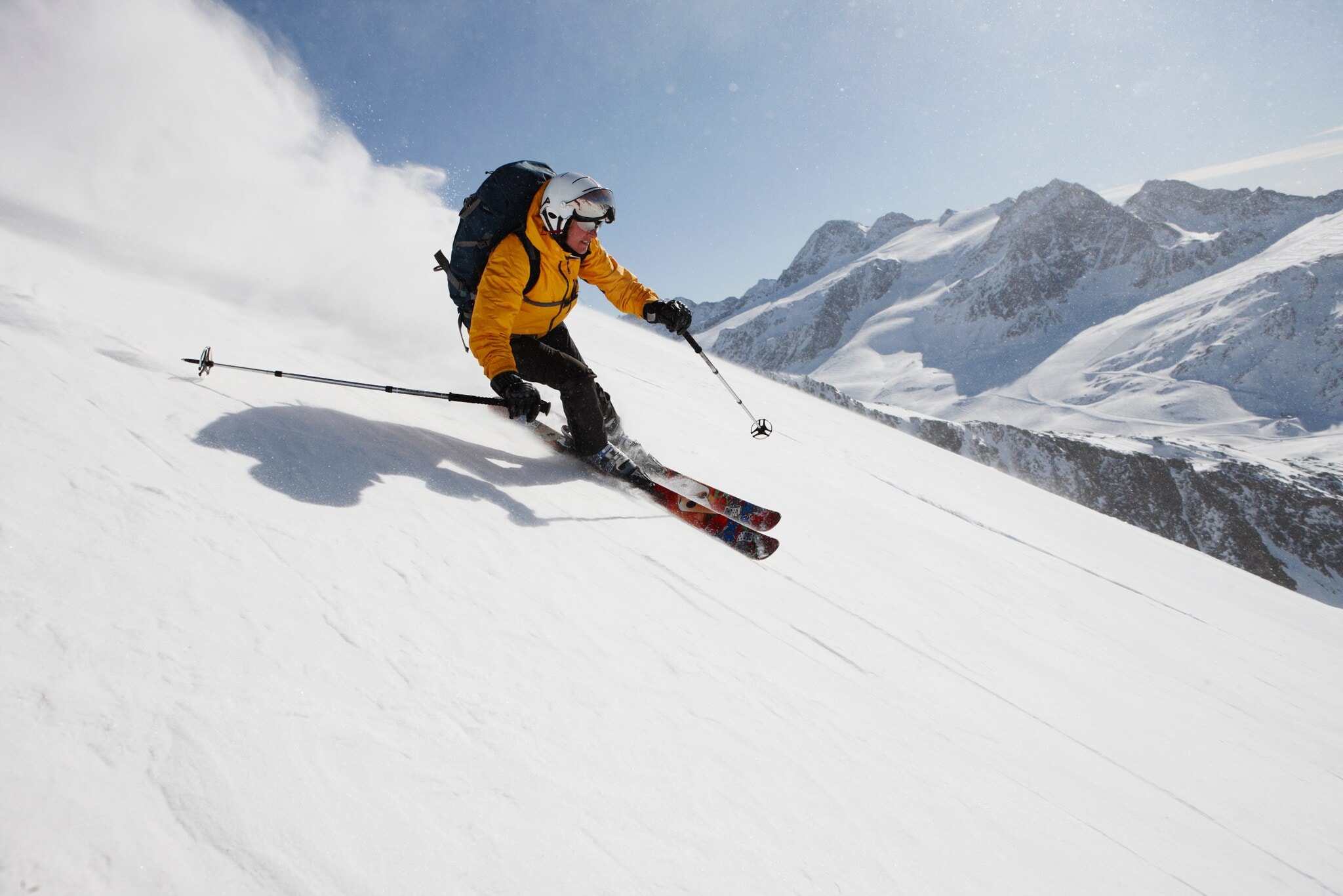 Eine skifahrende Person auf einer Piste vor Bergpanorama. Eine skifahrende Person auf einer Piste vor Bergpanorama.