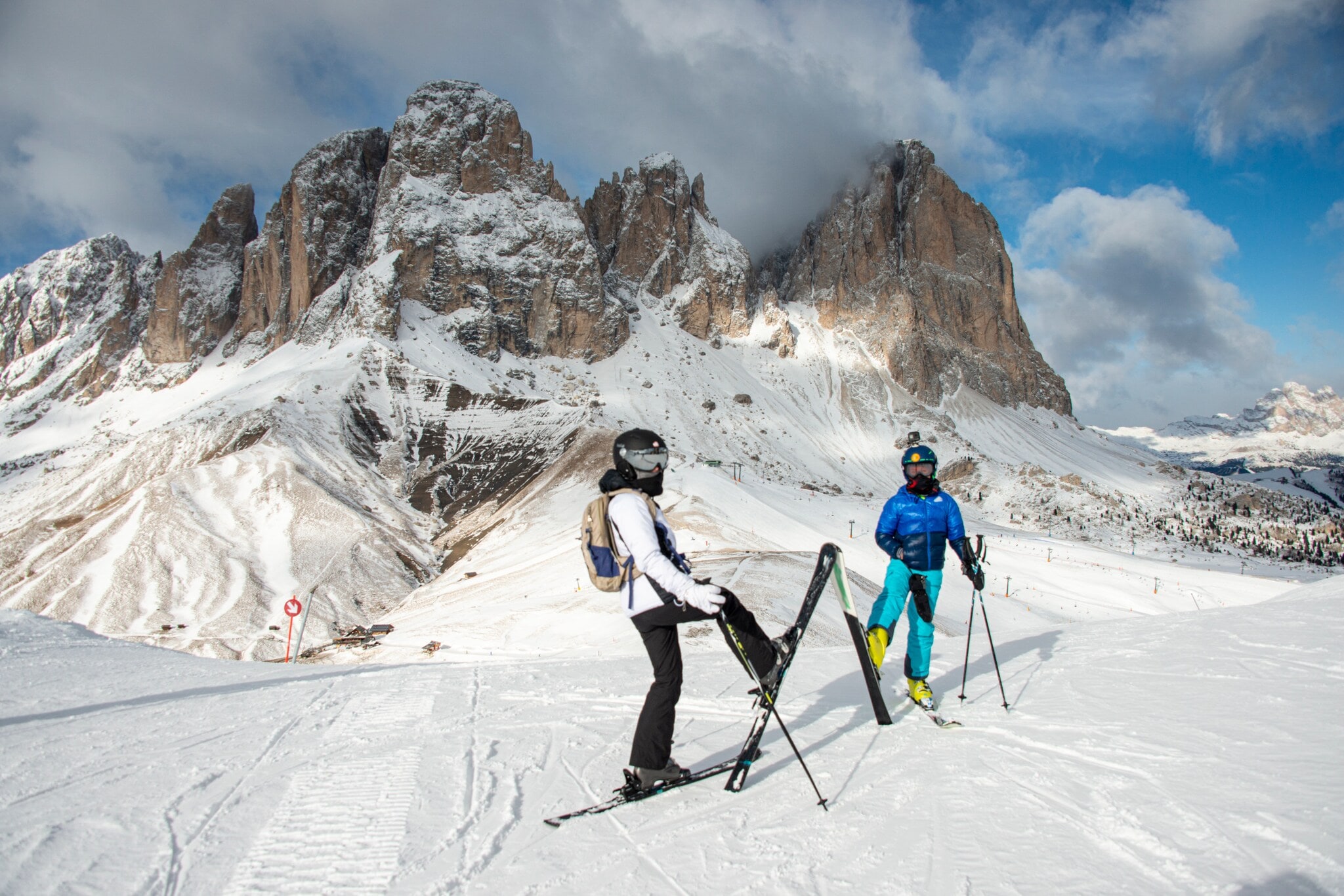 Zwei Personen stehen auf einer Skipiste vor einer Bergkulisse. Zwei Personen stehen auf einer Skipiste vor einer Bergkulisse.
