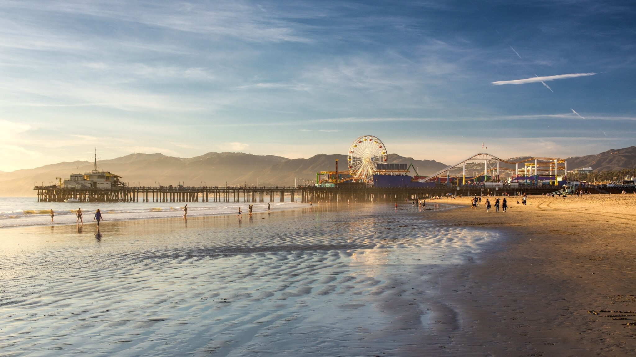 Ein Pier mit Freizeitpark an einem weitläufigen Sandstrand bei Sonnenuntergang. Ein Pier mit Freizeitpark an einem weitläufigen Sandstrand bei Sonnenuntergang.
