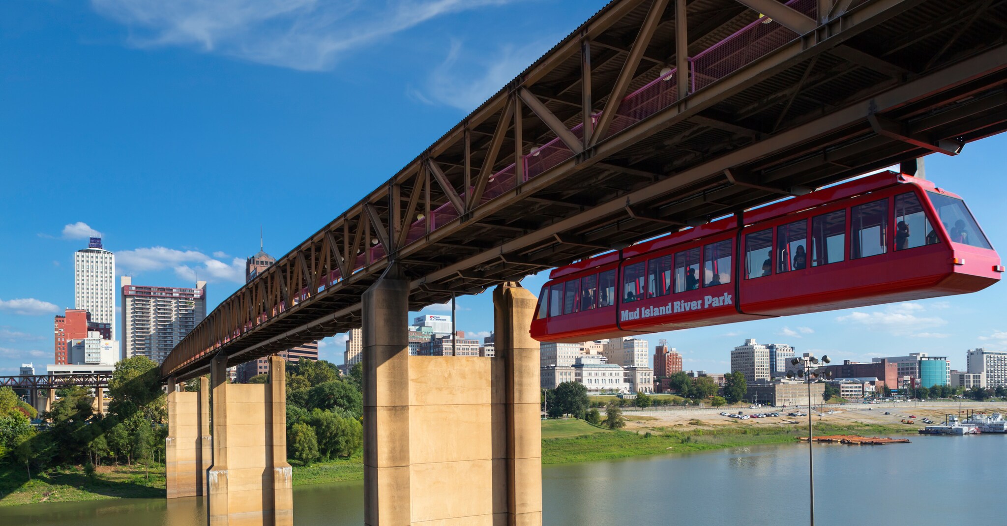 Rote Schwebebahn an einer Brücke über einem Fluss.