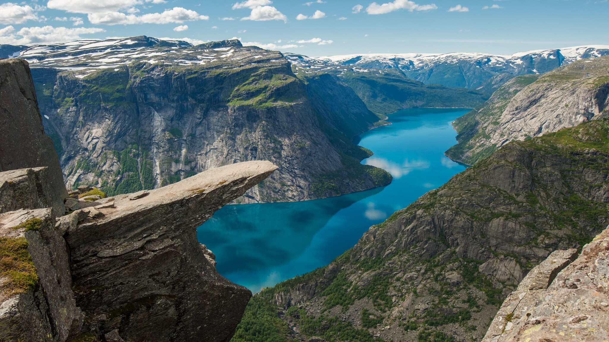 Felsvorsprung Trolltunga in Norwegen mit Fjord und Klippen im Hintergrund.