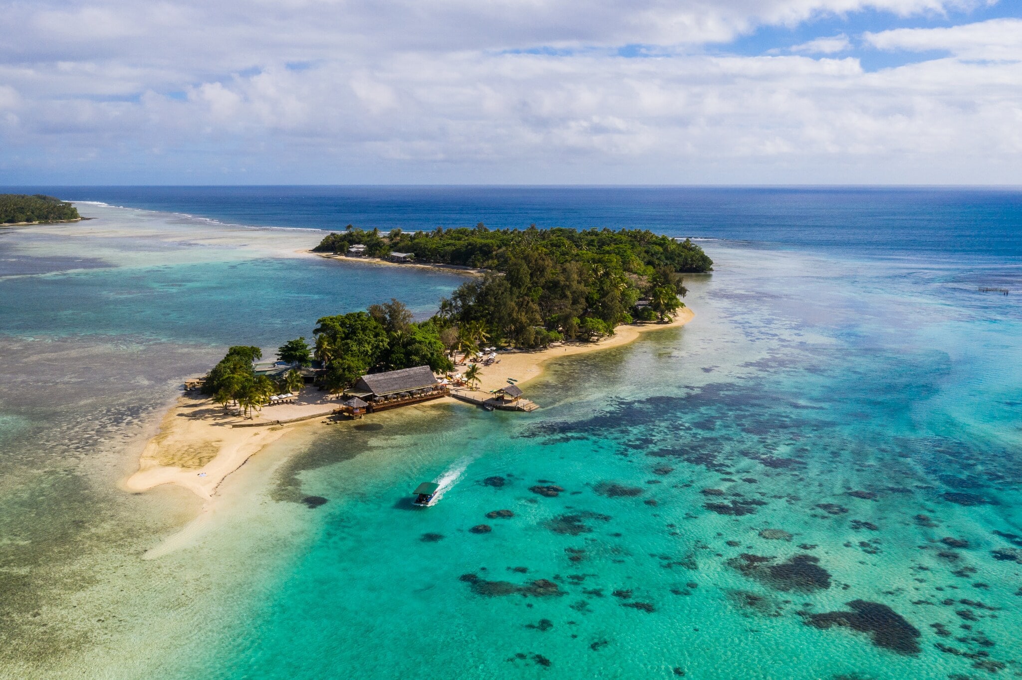 Kleine Insel mit Mangrovenwald und Bootsanleger an einem hellen Sandstrand, umgeben von türkisblauem Meer. Kleine Insel mit Mangrovenwald und Bootsanleger an einem hellen Sandstrand, umgeben von türkisblauem Meer.