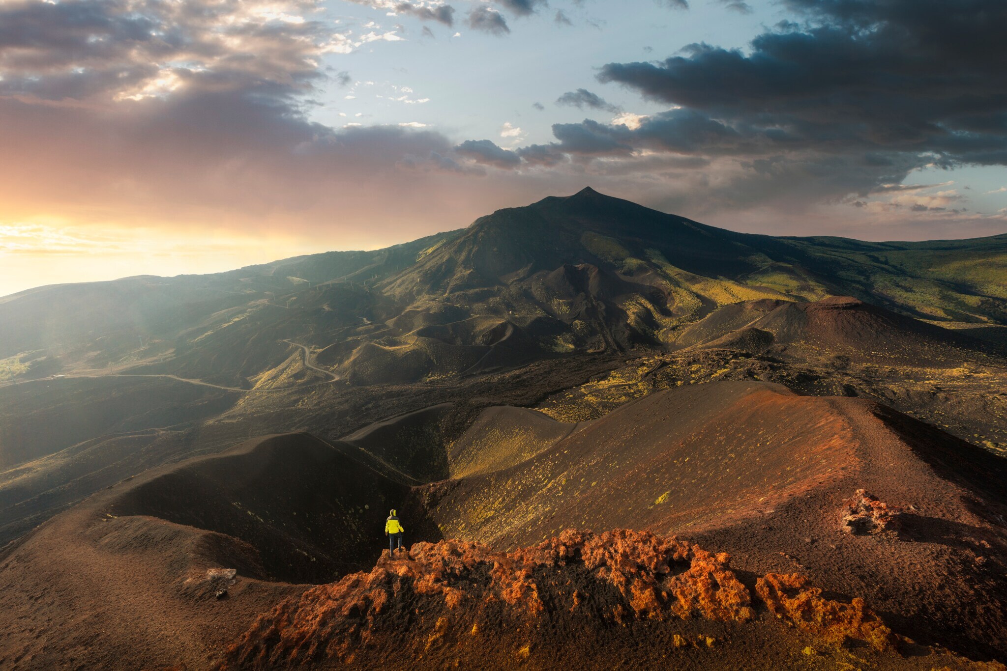 Blick von oben auf eine Person, die an einem Kraterrand steht. Blick von oben auf eine Person, die an einem Kraterrand steht.