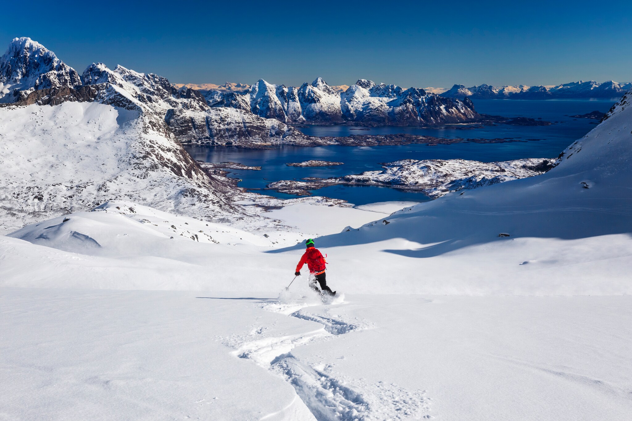 Person auf Skiern, im Hintergrund Berge und Wasser. Person auf Skiern, im Hintergrund Berge und Wasser.