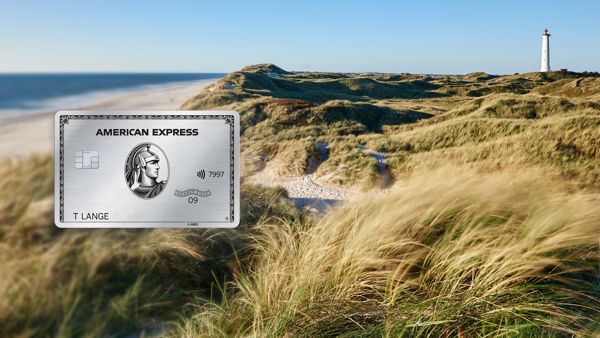 Grasbewachsene Dünenlandschaft am Meer mit Leuchtturm in der Ferne. Grasbewachsene Dünenlandschaft am Meer mit Leuchtturm in der Ferne.