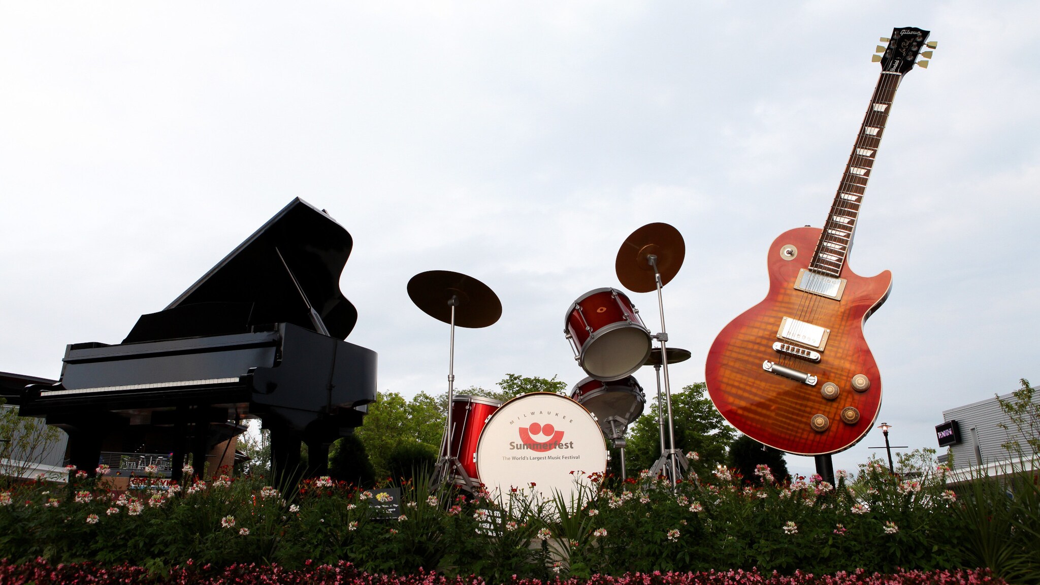 Ein Piano, Schlagzeug und eine E-Gitarre ausgestellt auf einem Blumenbeet im Rahmen des Milwaukee Summerfest Festivals in den USA. Ein Piano, Schlagzeug und eine E-Gitarre ausgestellt auf einem Blumenbeet im Rahmen des Milwaukee Summerfest Festivals in den USA.