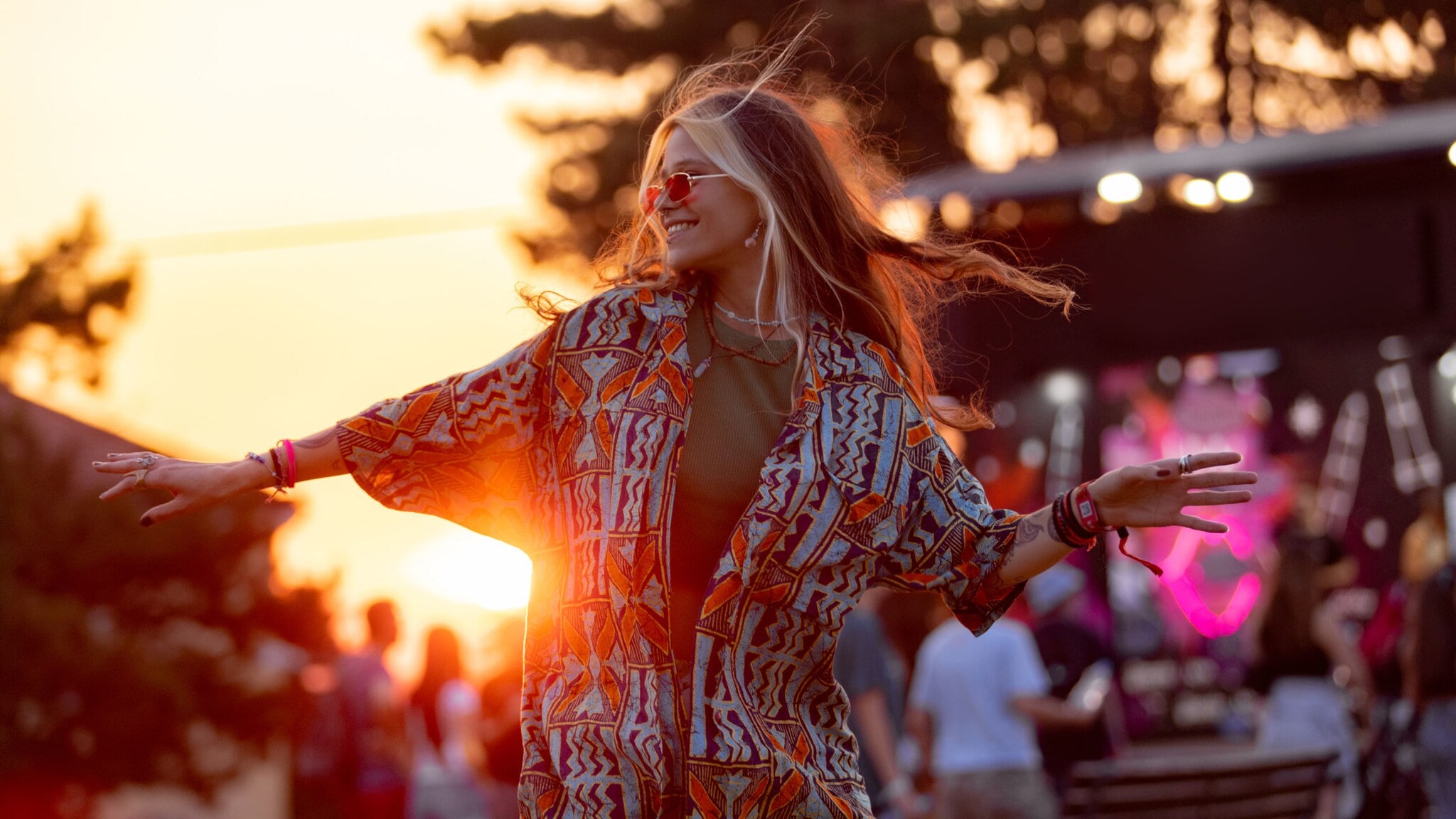 Eine Frau, die bei Sonnenuntergang vor einer Bühne tanzt. Eine Frau, die bei Sonnenuntergang vor einer Bühne tanzt.