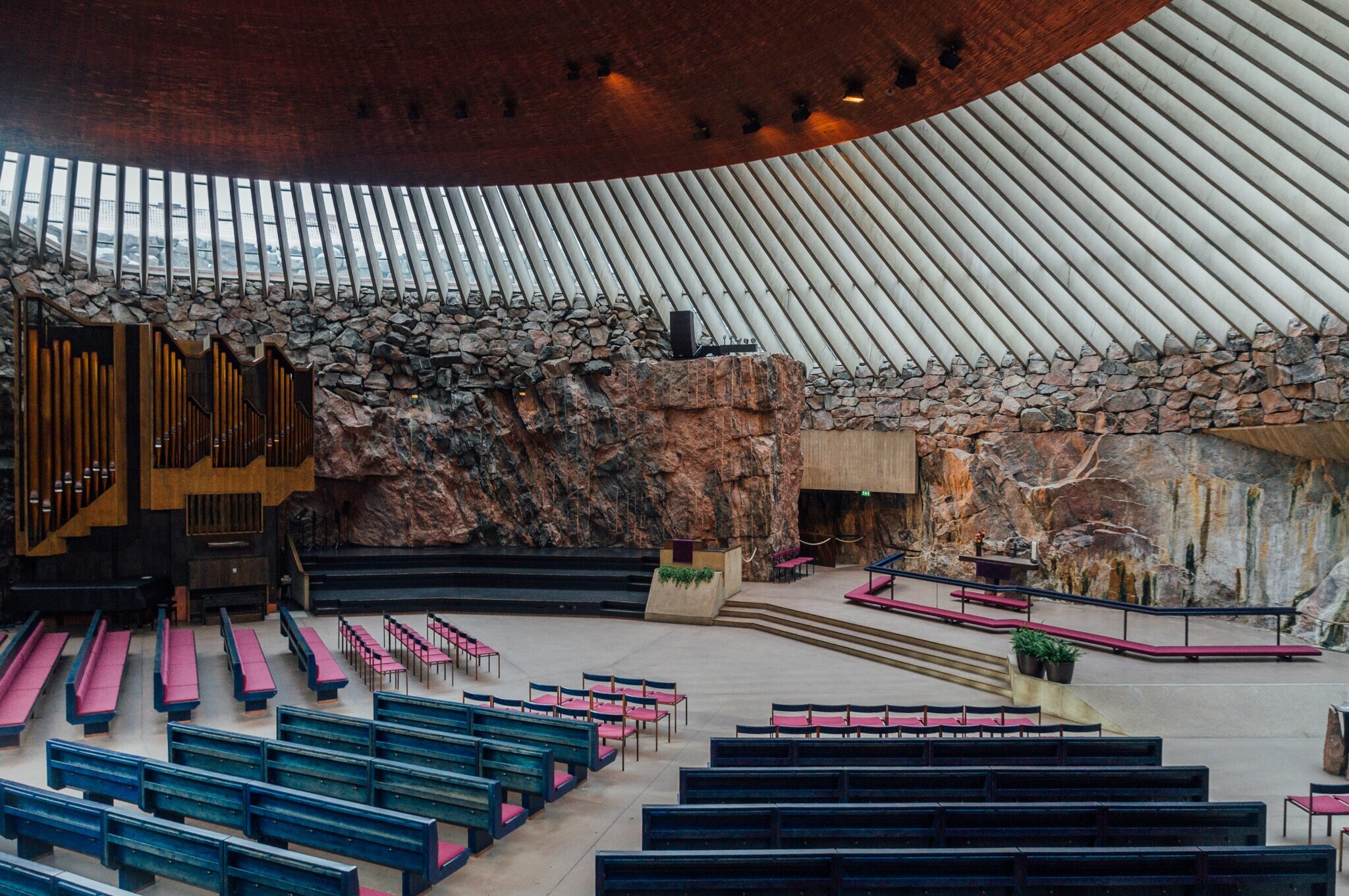 Altarraum mit Orgel in einer modernen Kirche mit Granitfelswand.
