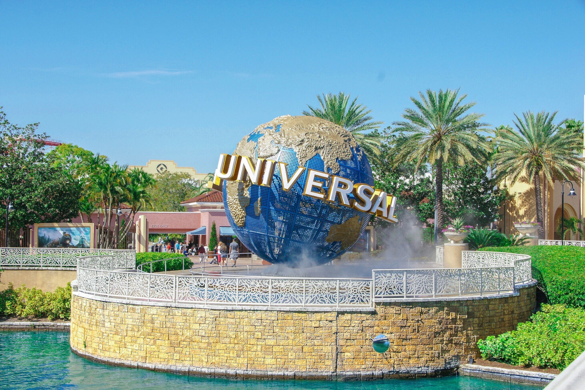 Skulptur einer Weltkugel mit Universal Schriftzug in einem Themenpark mit Palmen. Skulptur einer Weltkugel mit Universal Schriftzug in einem Themenpark mit Palmen.