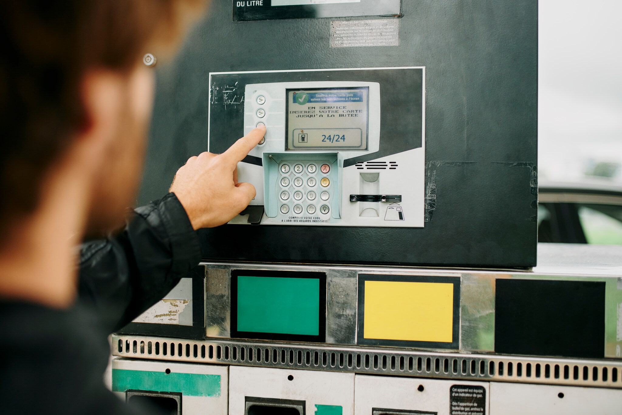 Hands, pay or gas station with fuel machine or transport cost for energy, price or petrol service. Travel, gasoline or driver person for amount on screen at diesel garage to refuel tank on road trip Nahaufnahme eines Mannes, der das Display eines Tankautomaten bedient.