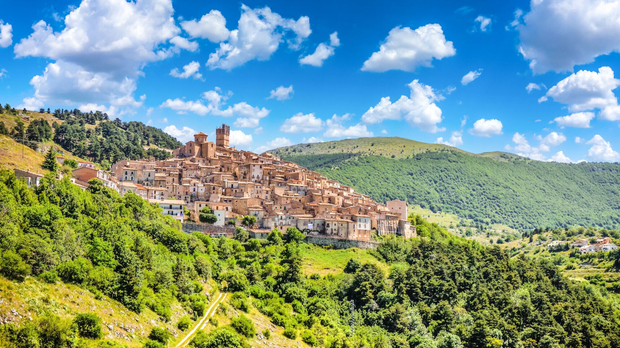 Steinhäuser an einem grün bewachsenen Berghang