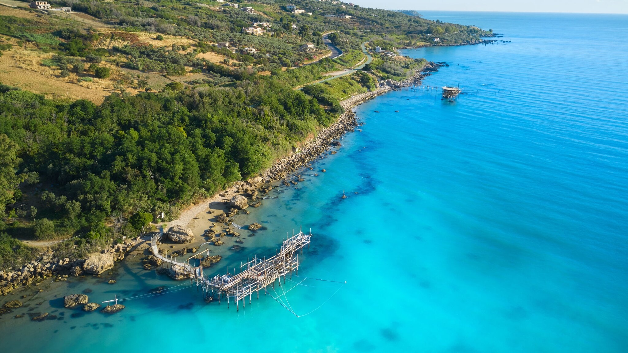 Küstenabschnitt Trabocchi in Italien mit Holzsteg, der ins Wasser ragt Küstenabschnitt Trabocchi in Italien mit Holzsteg, der ins Wasser ragt