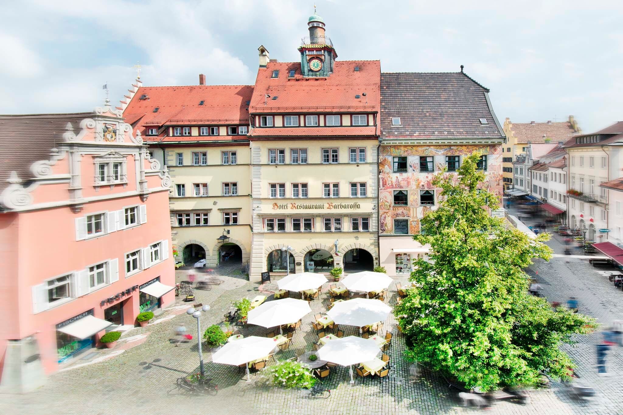 Blick auf begrünten und kopfsteingepflasterten Obermarkt mit dahinterliegender Häuserfassade mit historischem Fresko. Blick auf begrünten und kopfsteingepflasterten Obermarkt mit dahinterliegender Häuserfassade mit historischem Fresko.