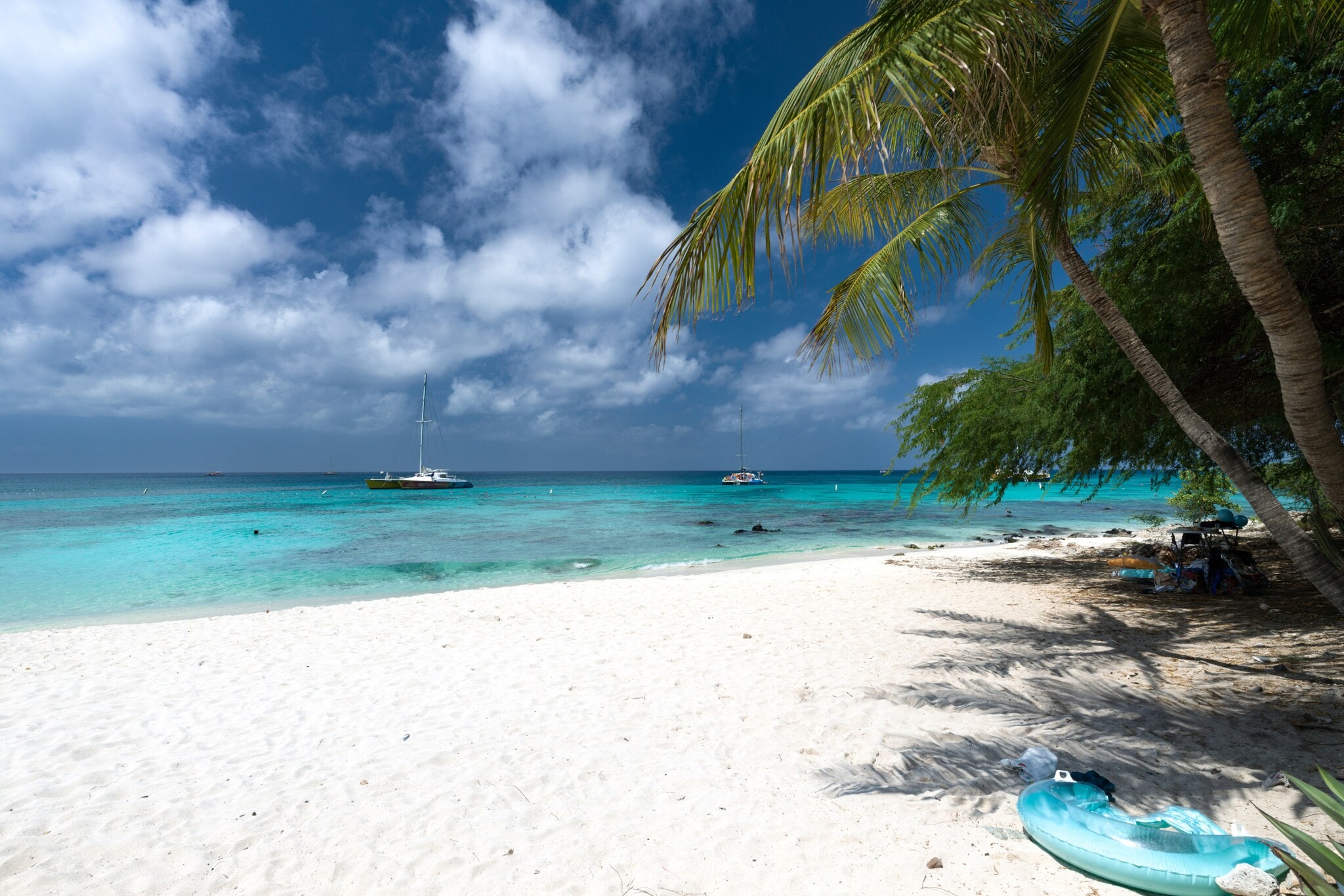 Weißer Strand und Palmen am türkisfarbenen Meer, auf dem Boote fahren. Weißer Strand und Palmen am türkisfarbenen Meer, auf dem Boote fahren.