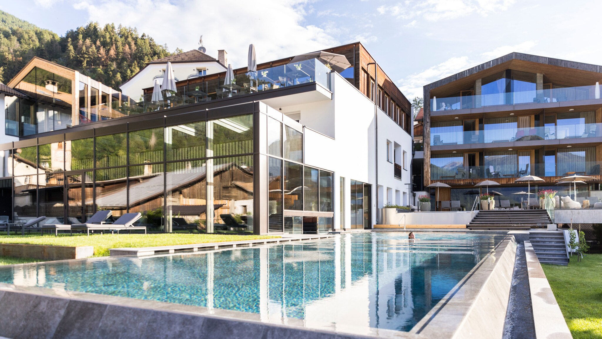 Blick auf das Hotel Weisses Kreuz mit Außenpool im Vordergrund.
