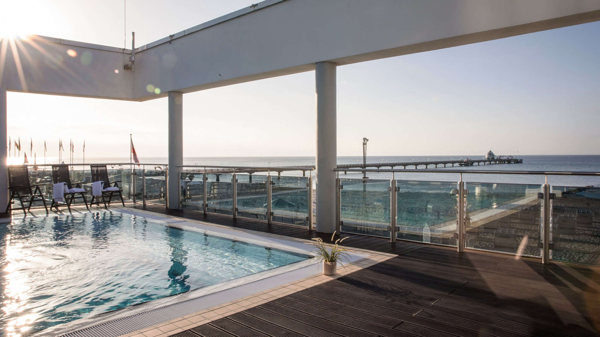 Hotelpool auf einer Dachterrasse mit Blick aufs Meer.