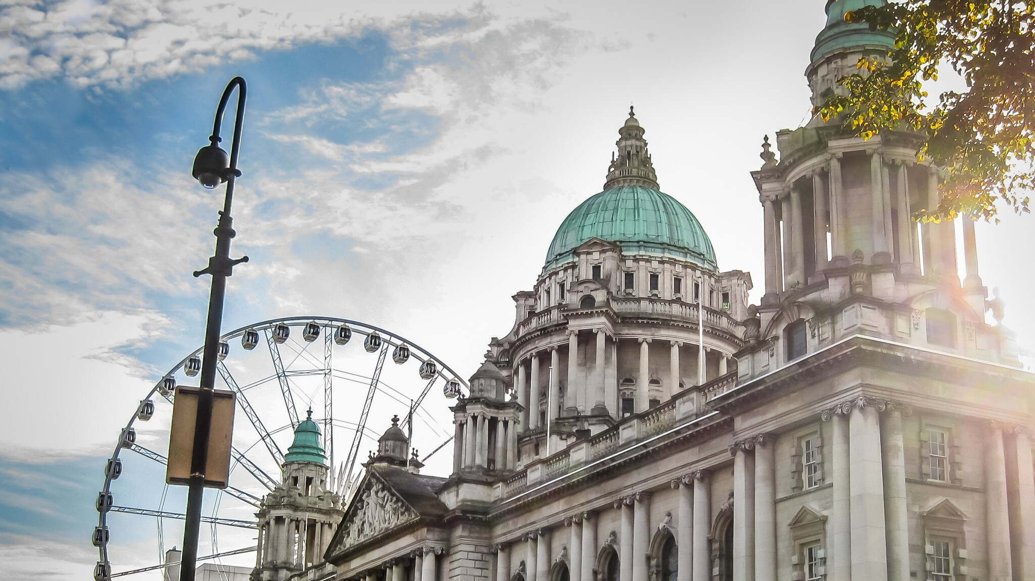 Historisches Gebäude mit grüner Kuppel und Riesenrad im Hintergrund bei Sonnenlicht Historisches Gebäude mit grüner Kuppel und Riesenrad im Hintergrund bei Sonnenlicht