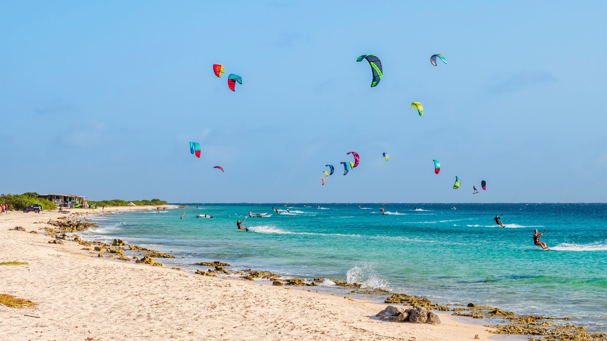 Zahlreiche Kitesurfende im türkisblauen Meer. Zahlreiche Kitesurfende im türkisblauen Meer.