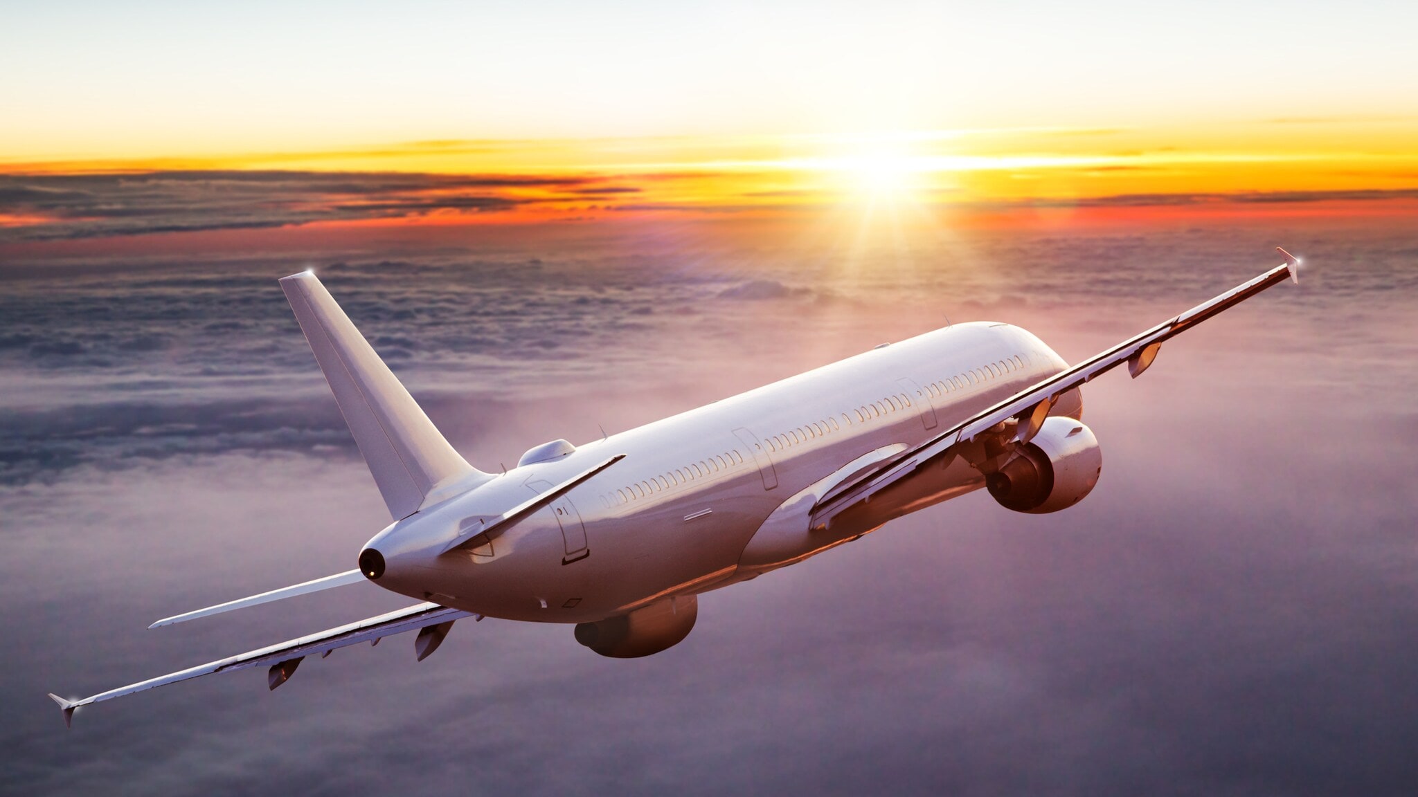 Ein geneigtes Passagierflugzeug über den Wolken bei Sonnenuntergang. Ein geneigtes Passagierflugzeug über den Wolken bei Sonnenuntergang.