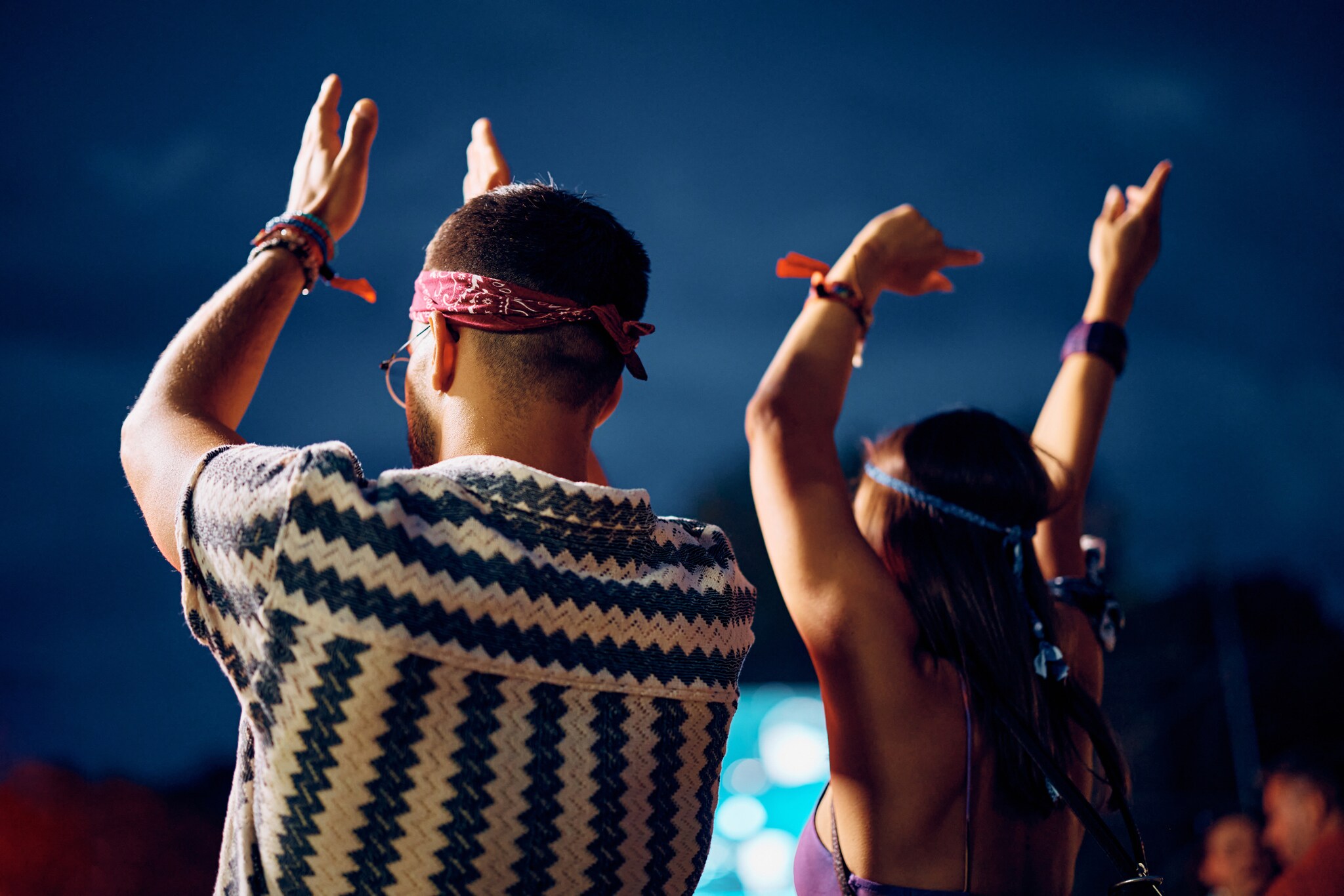 Zwei Personen im Vintage-Look, die von hinten zu sehen sein, klatschen und halten die Arme hoch.