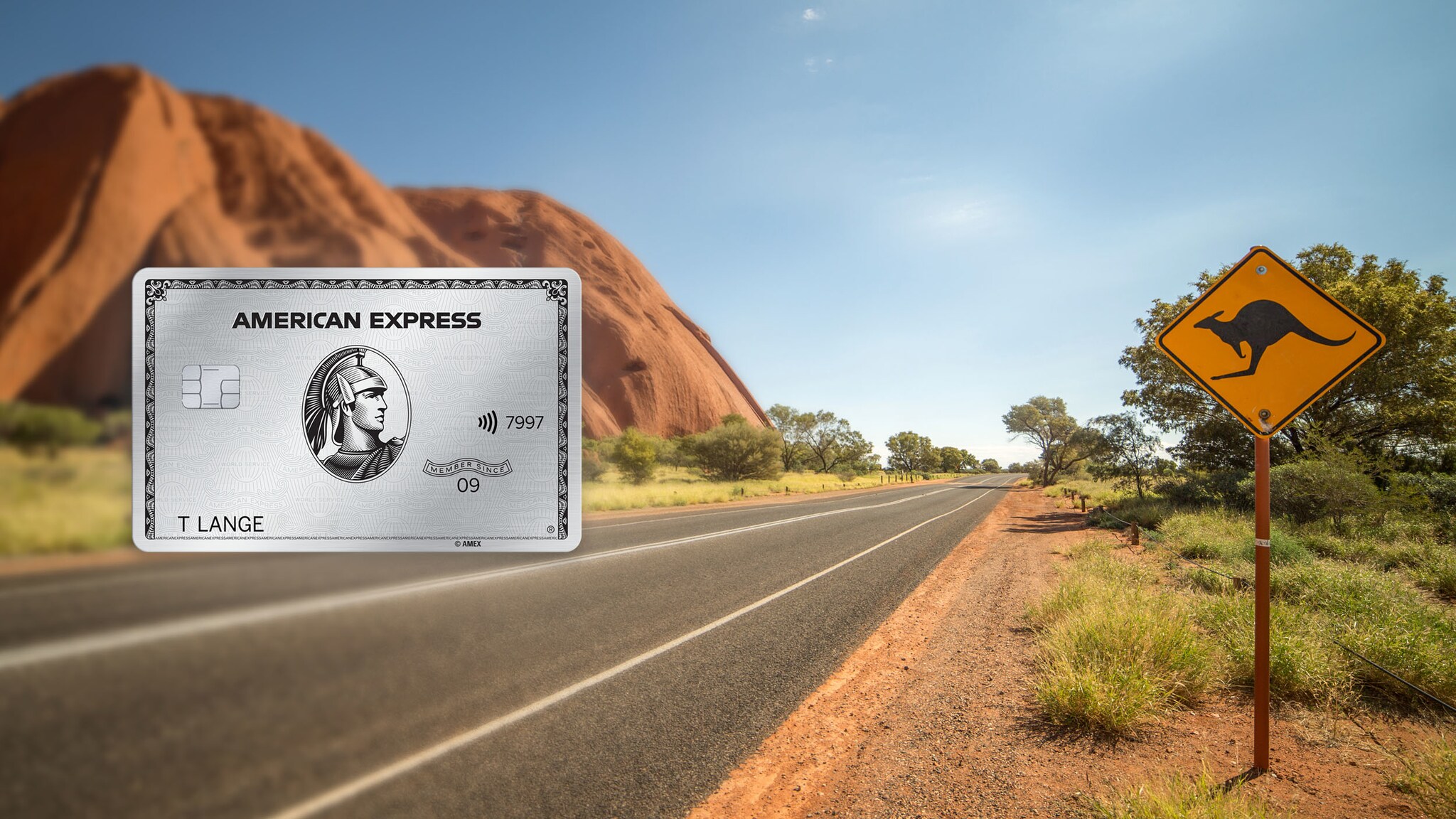 Eine Schnellstraße in einer Steppenlandschaft mit einem roten Felsen und einem Warnschild mit Känguru-Motiv. Eine Schnellstraße in einer Steppenlandschaft mit einem roten Felsen und einem Warnschild mit Känguru-Motiv.