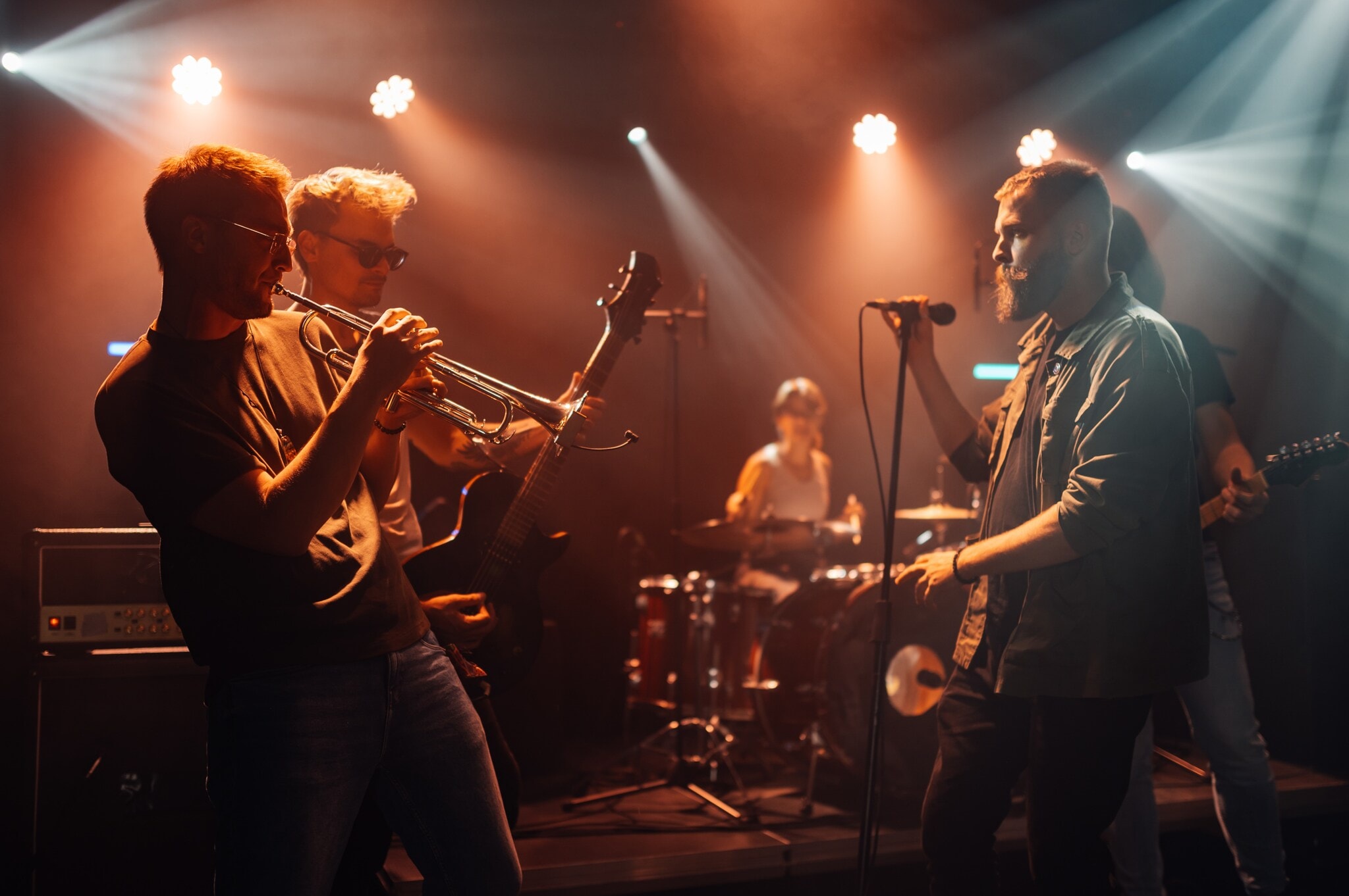 Musiker:innen spielen und singen auf einer Bühne. Musiker:innen spielen und singen auf einer Bühne.