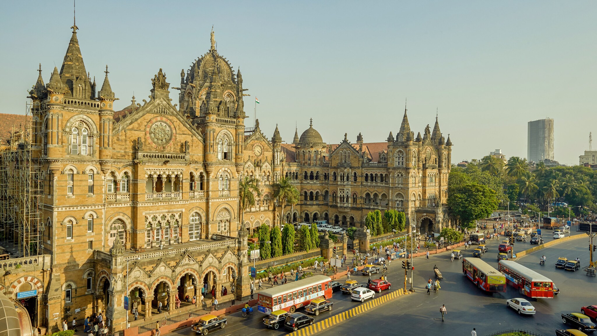 Historisches Gebäude mit gotischen Elementen in Mumbai mit Verkehr und Bussen.