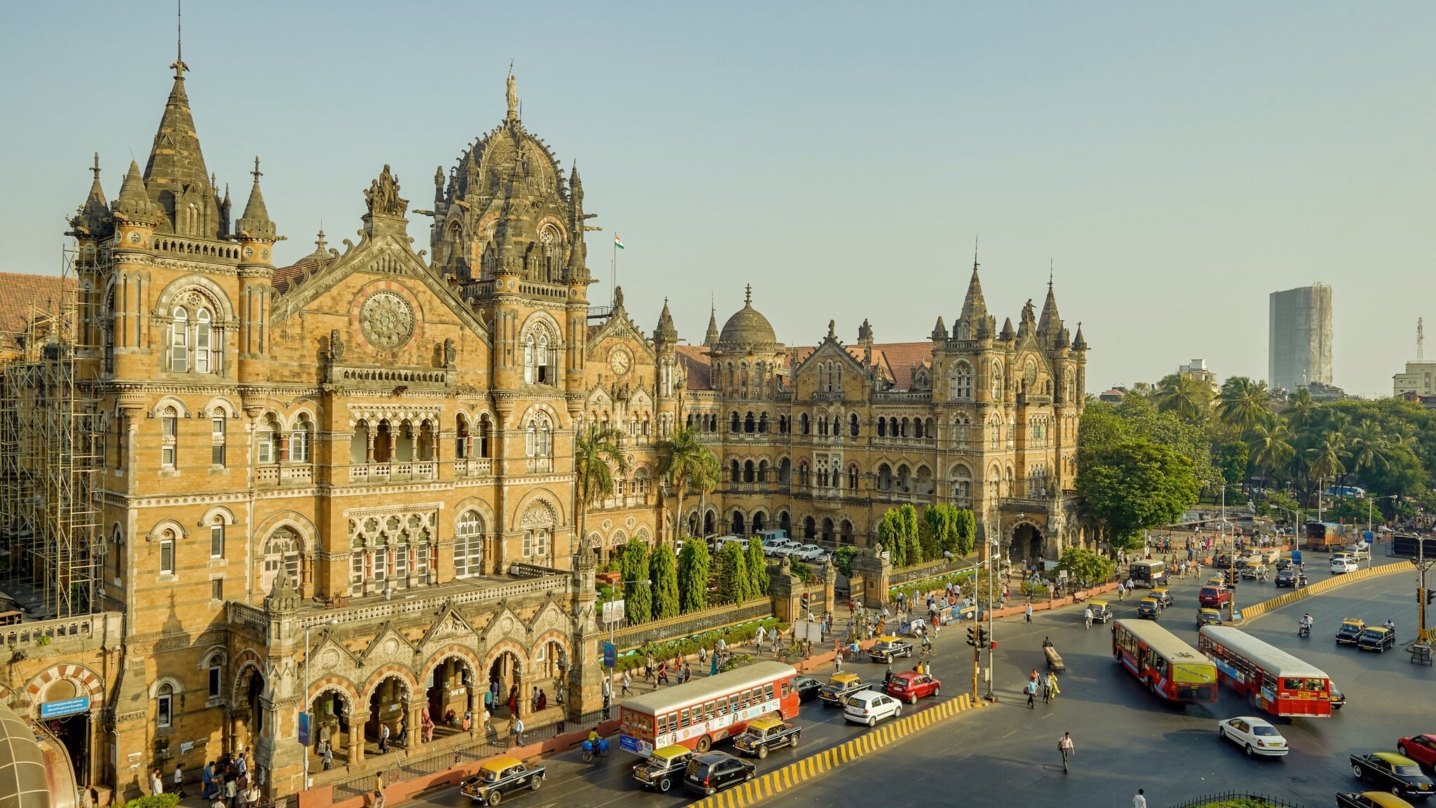 Historisches Gebäude mit gotischen Elementen in Mumbai mit Verkehr und Bussen. Historisches Gebäude mit gotischen Elementen in Mumbai mit Verkehr und Bussen.