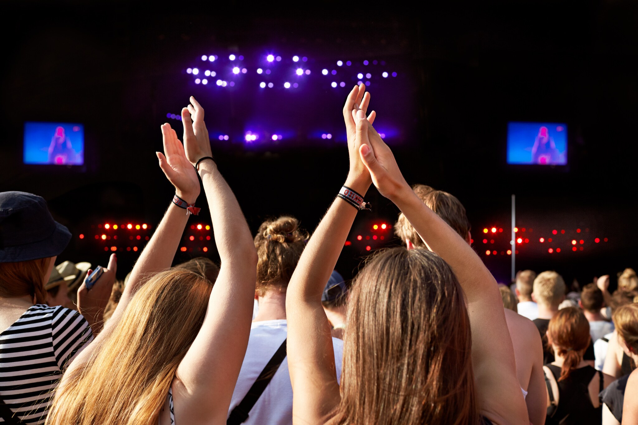 Zwei Personen applaudieren mit hoch erhobenen Armen während eines Konzerts auf dem Roskilde Festival. Zwei Personen applaudieren mit hoch erhobenen Armen während eines Konzerts auf dem Roskilde Festival.