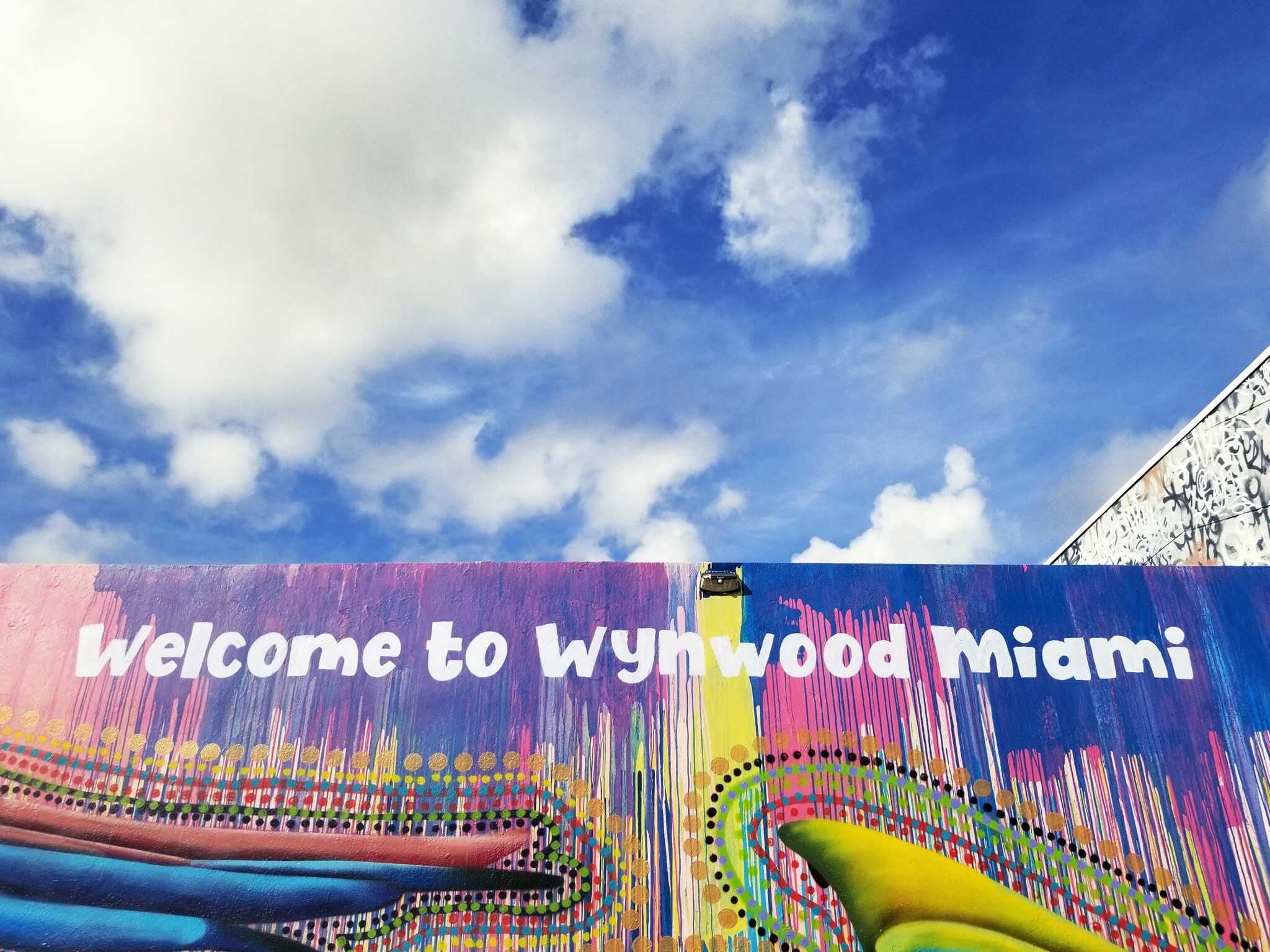 Ein buntes Streetart-Plakat mit der Aufschrift Welcome to Wynwood Miami Ein buntes Streetart-Plakat mit der Aufschrift Welcome to Wynwood Miami