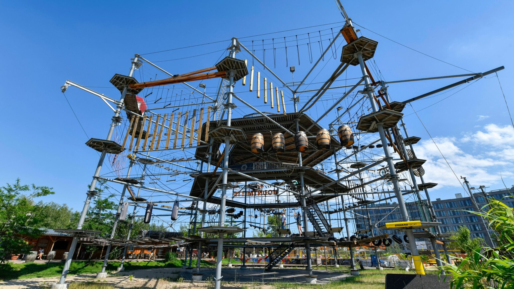 Hochseilgarten mit verschiedenen Kletterelementen und Plattformen unter blauem Himmel.