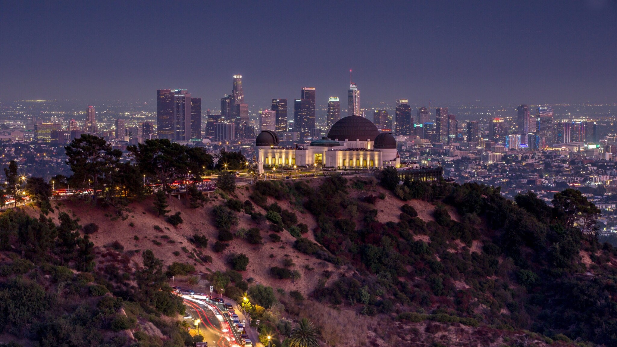 Beleuchtete Sternwarte auf einem Hügel vor der Skyline von Los Angeles bei Nacht. Beleuchtete Sternwarte auf einem Hügel vor der Skyline von Los Angeles bei Nacht.