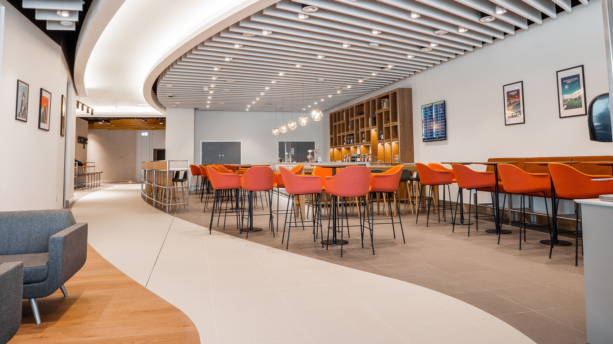 Barbereich mit Sitzgelegenheiten an einem Durchgang einer modernen Flughafen-Lounge.