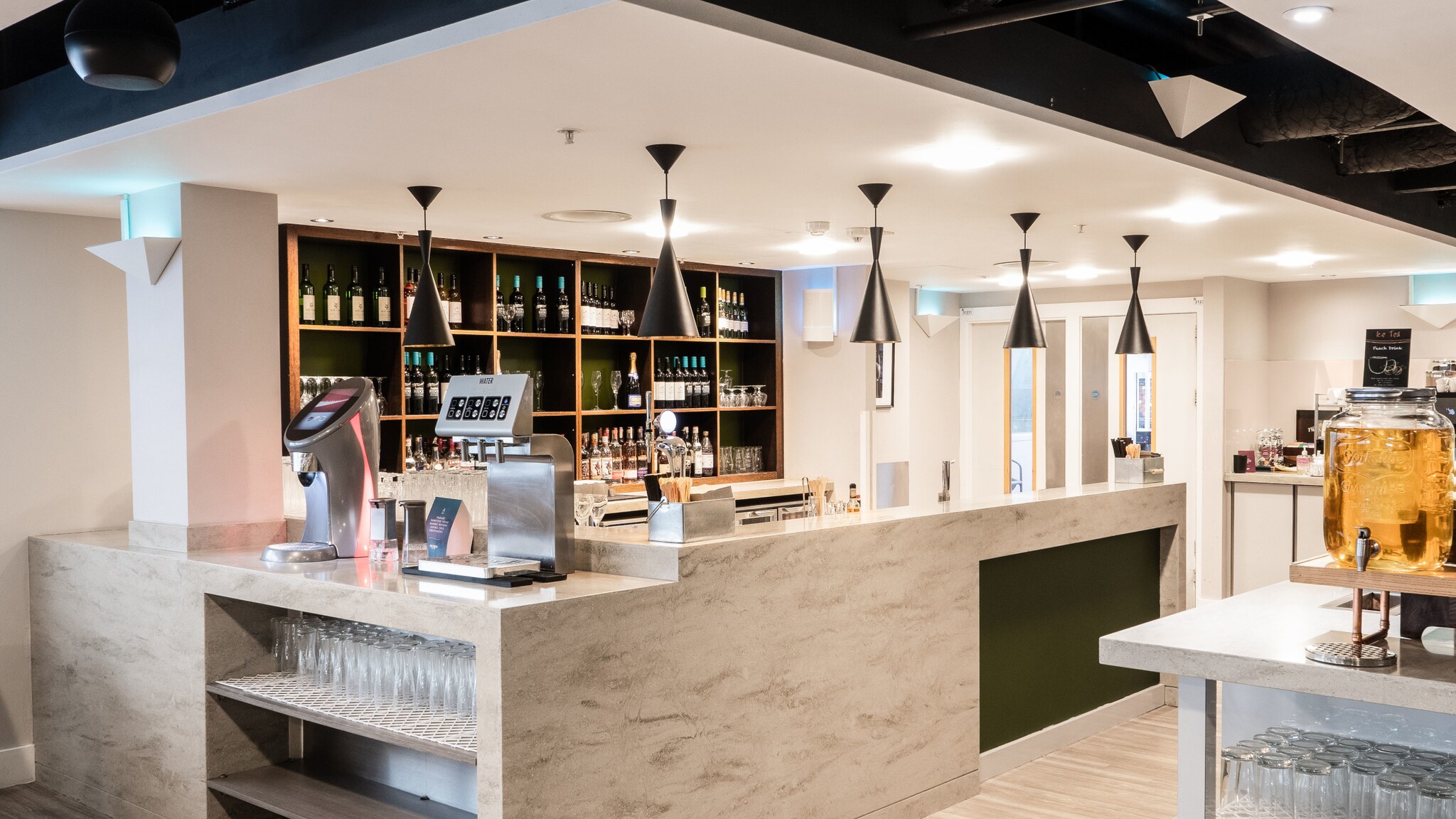 Moderner, menschenleerer Barbereich mit Tresen aus hellem Stein. Moderner, menschenleerer Barbereich mit Tresen aus hellem Stein.