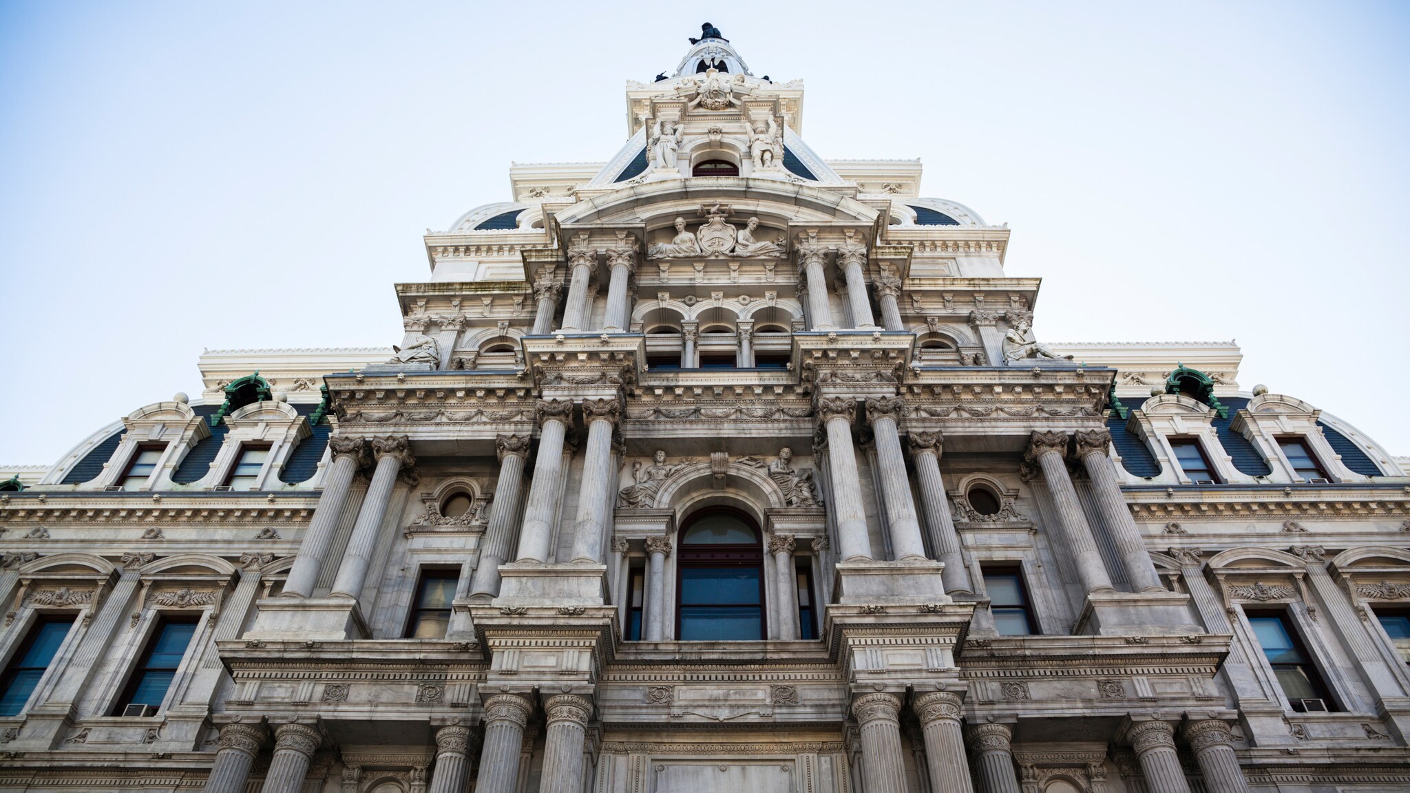 Fassade eines historischen Gebäudes mit Säulen und detaillierter Steinarchitektur, Blick nach oben Fassade eines historischen Gebäudes mit Säulen und detaillierter Steinarchitektur, Blick nach oben
