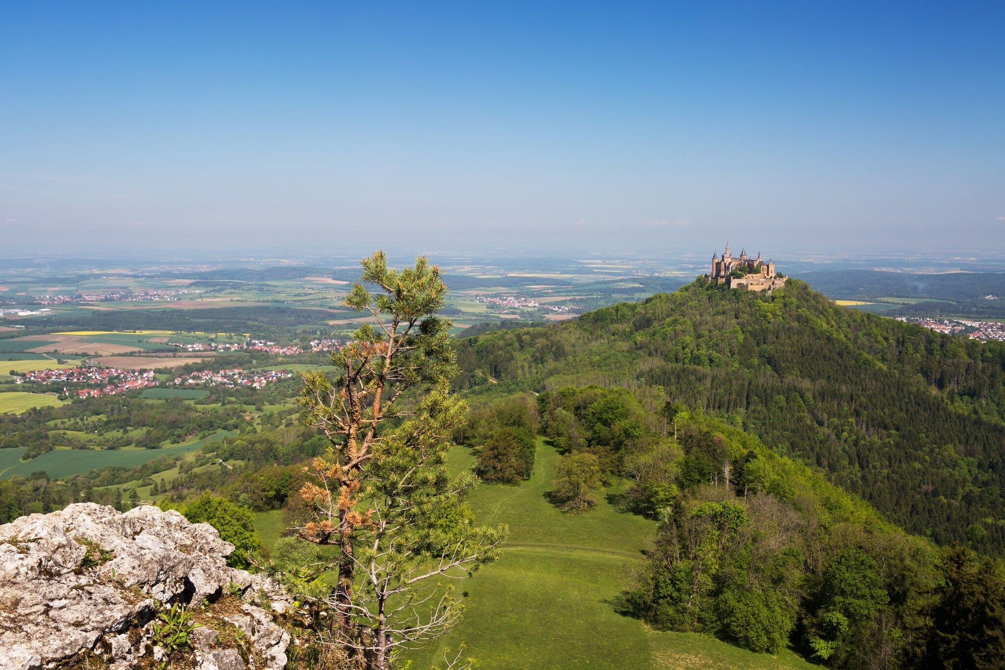 Die Burg Hohenzollern in grüner Landschaft.