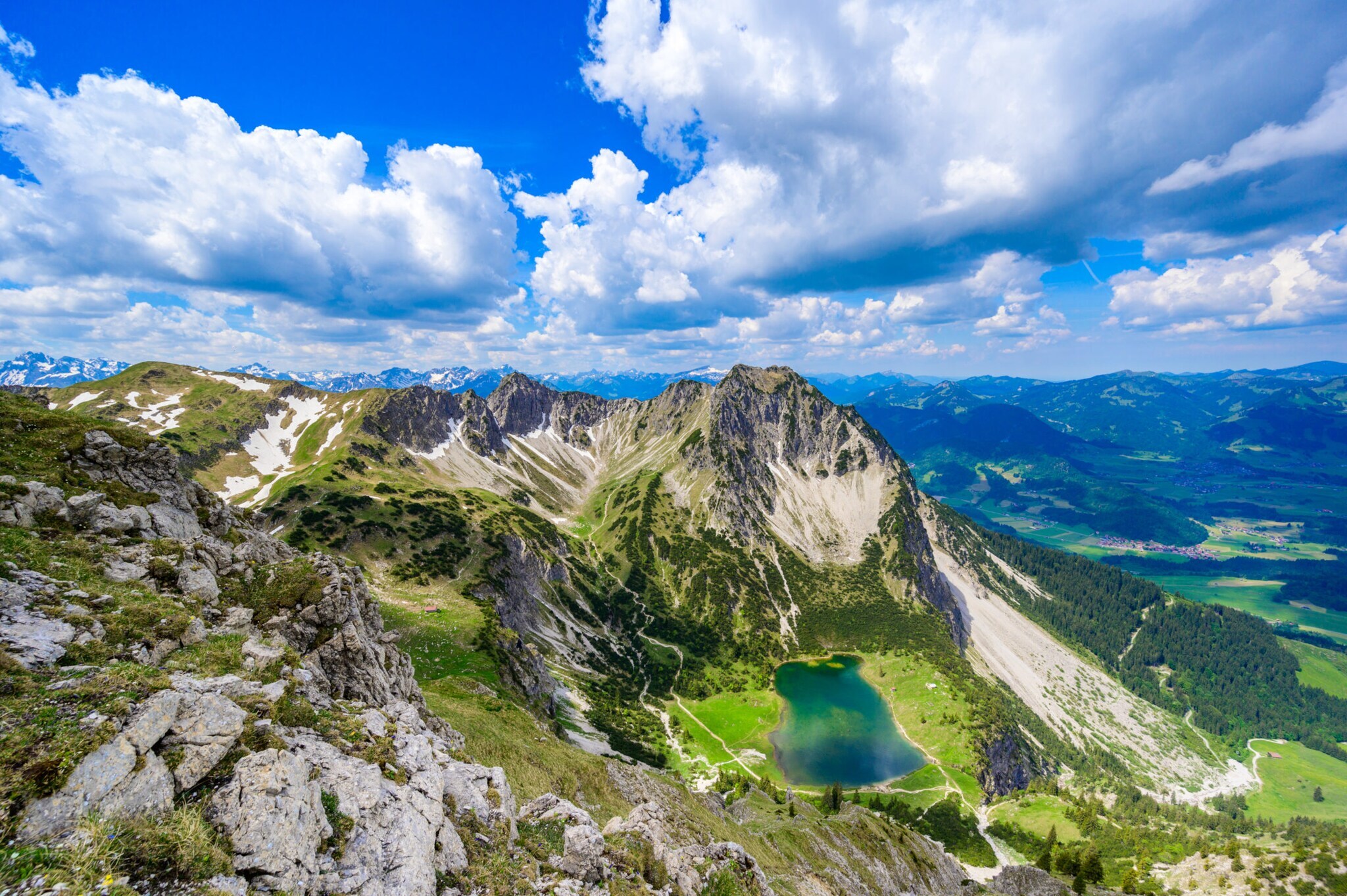 Luftaufnahme eines blaugrünen Bergsees unterhalb eines schroffen Gipfels. Luftaufnahme eines blaugrünen Bergsees unterhalb eines schroffen Gipfels.