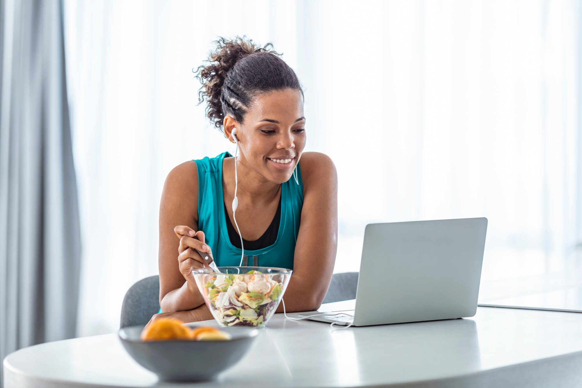 Meal-Prep fürs Büro: Lunch-Ideen für stressfreie und produktive Arbeitstage Eine Frau isst einen Salat an ihrem Arbeitsplatz.