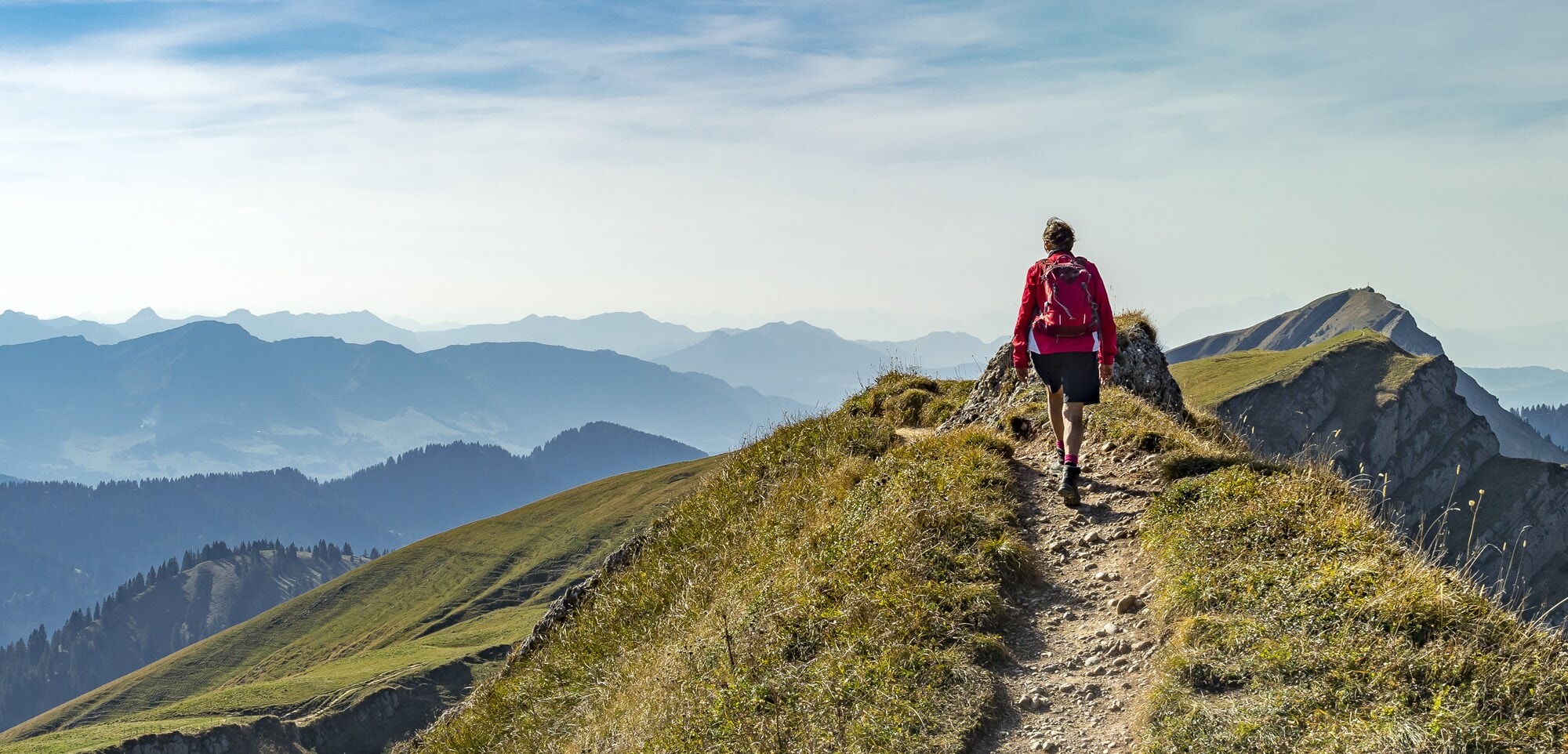 Workation in den Bergen: Nach der Arbeit zum Wandern oder Mountainbiken Eine Frau wandert in den Bergen.